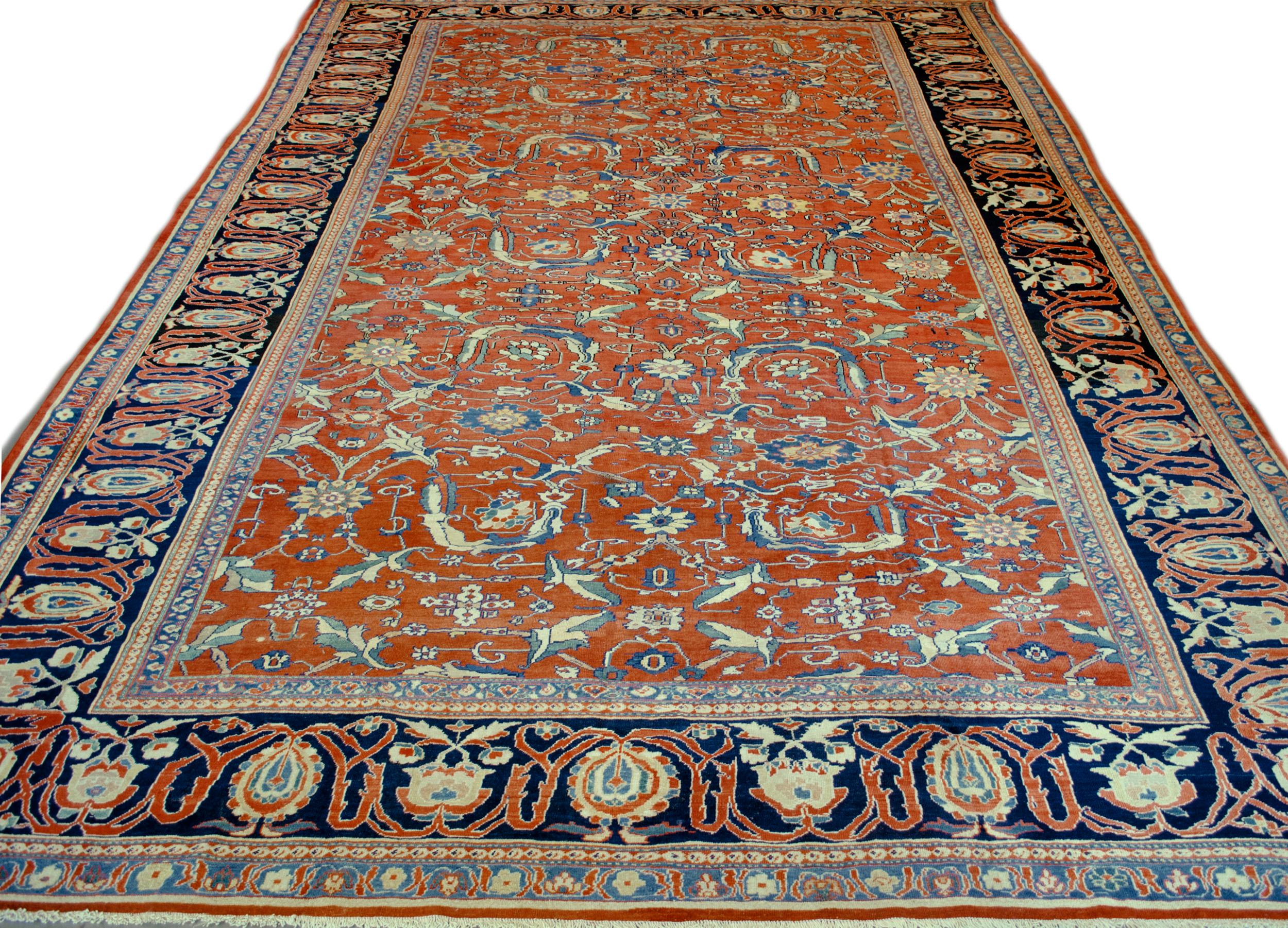 Ce tapis traditionnel persan Fereghan tissé à la main présente un champ rouge brique de pendentifs en rosette émettant des vignes stylisées formant un treillis en losange, entourant d'autres motifs floraux fins, dans une bordure de cyprès et de