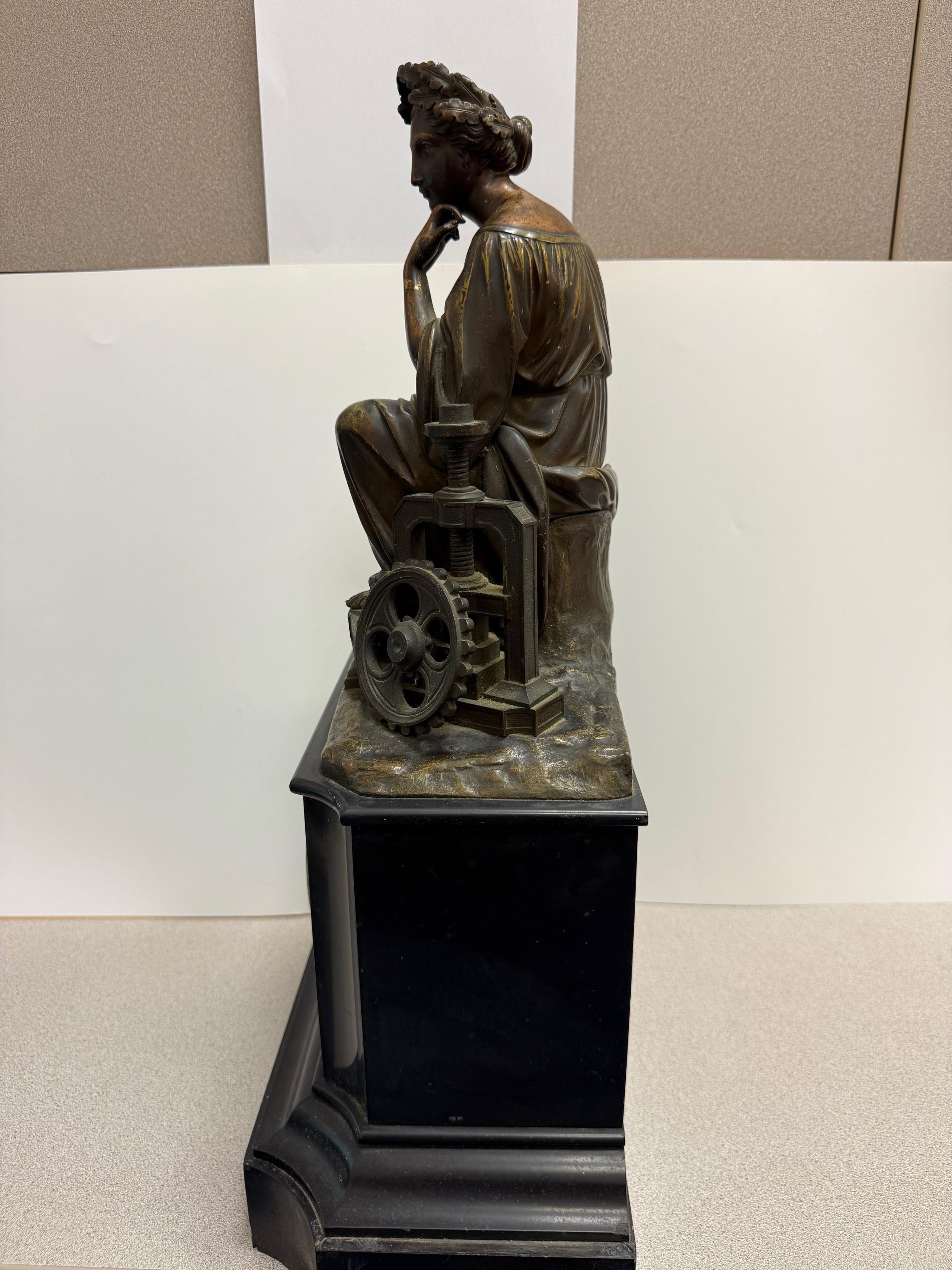 Beautiful Late 19th Century figural bronze and marble mantel clock with a bronze sculpture of a Muse, depicting the Industrial Revolution on top of a marble mantel clock. The Muse carries a compass in her left hand, and her foot is resting on an