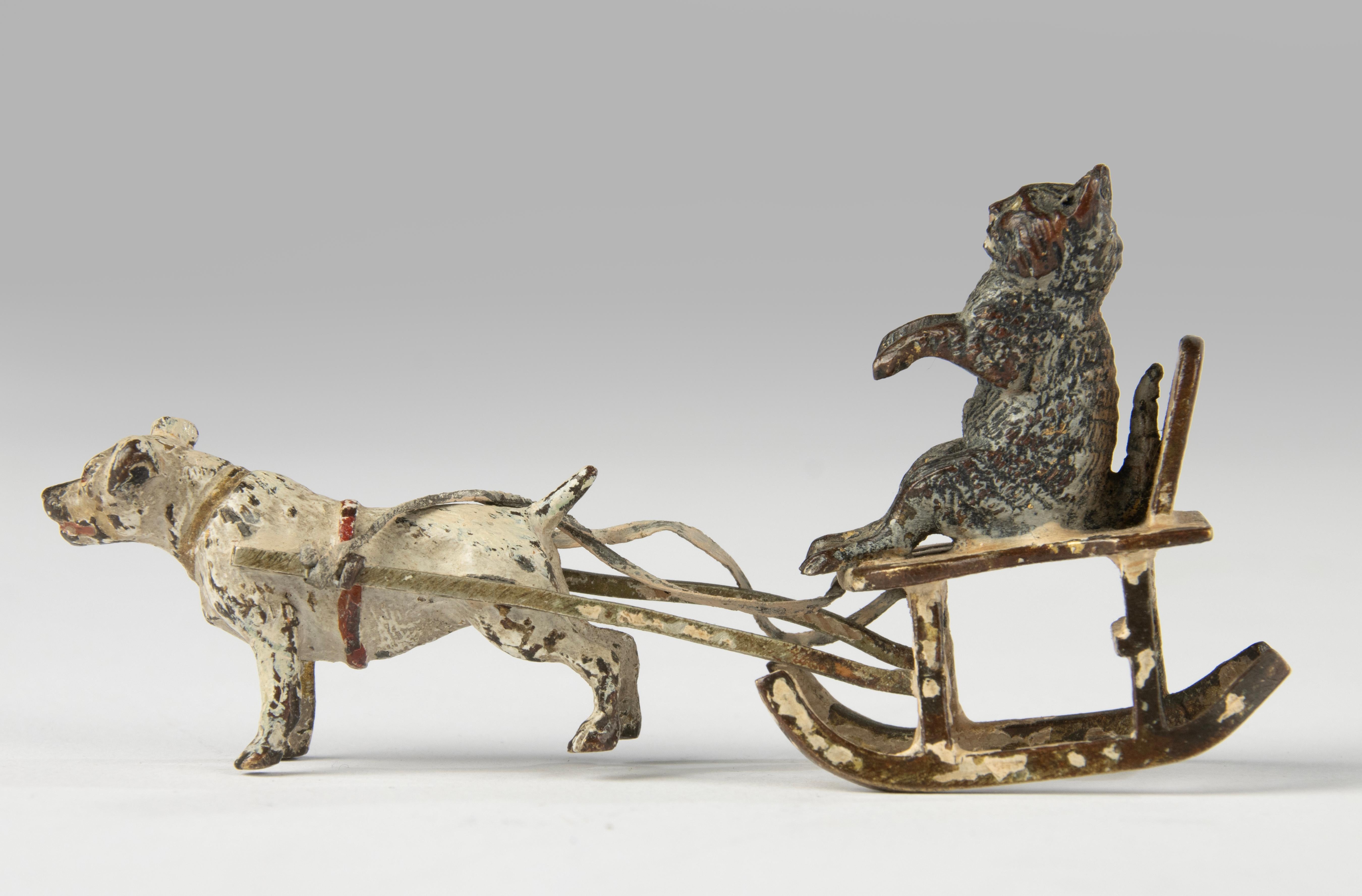 Charmante et humoristique figurine en bronze de Vienne peinte à froid datant d'environ 1900, représentant un chien tirant un chat assis sur un traîneau traditionnel. Cette scène ludique reflète l'esprit fantaisiste et le travail méticuleux qui font