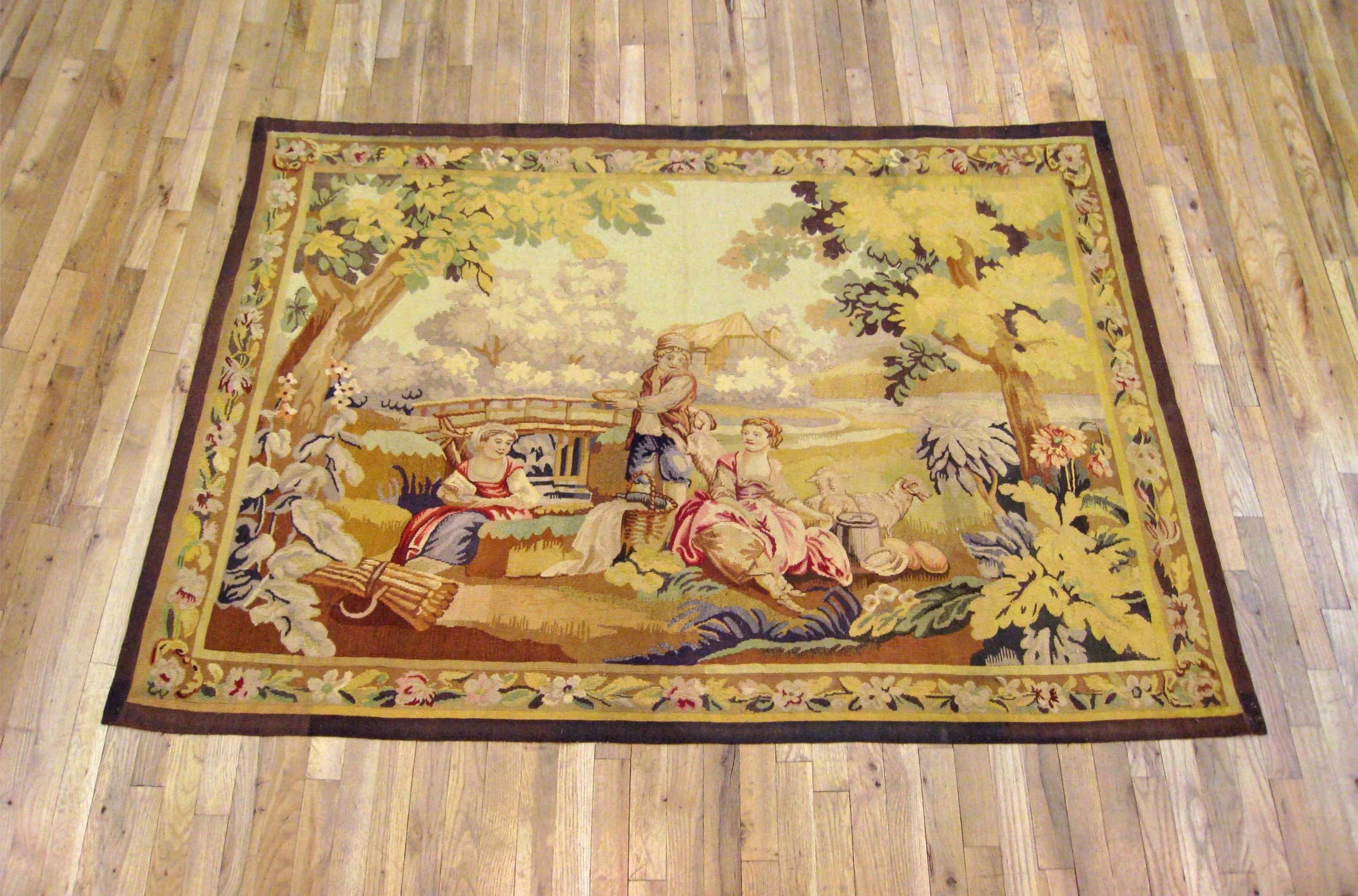 A French Aubusson pastoral tapestry from the late 19th century, featuring a tranquil scene with a young swain standing amidst seated ladies having a picnic, while their flock reposes in the verdant setting under the warm sun. Inspired by François