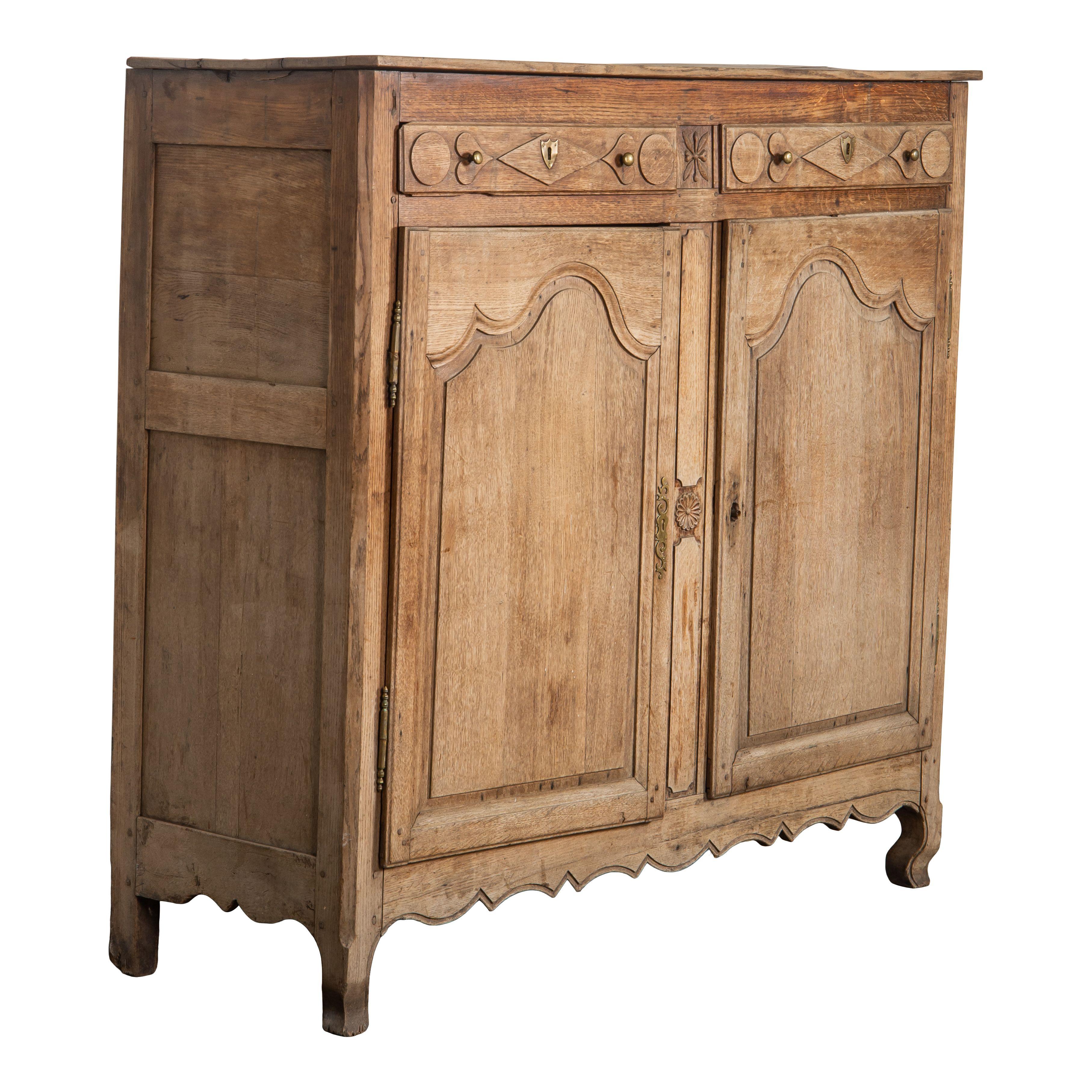 A beautiful vintage wood cabinet from France and made in the late 19th century. This antique cabinet is classically simple, but also features intricate and detailed carved embellishments. This piece is the perfect homey addition to any space and is