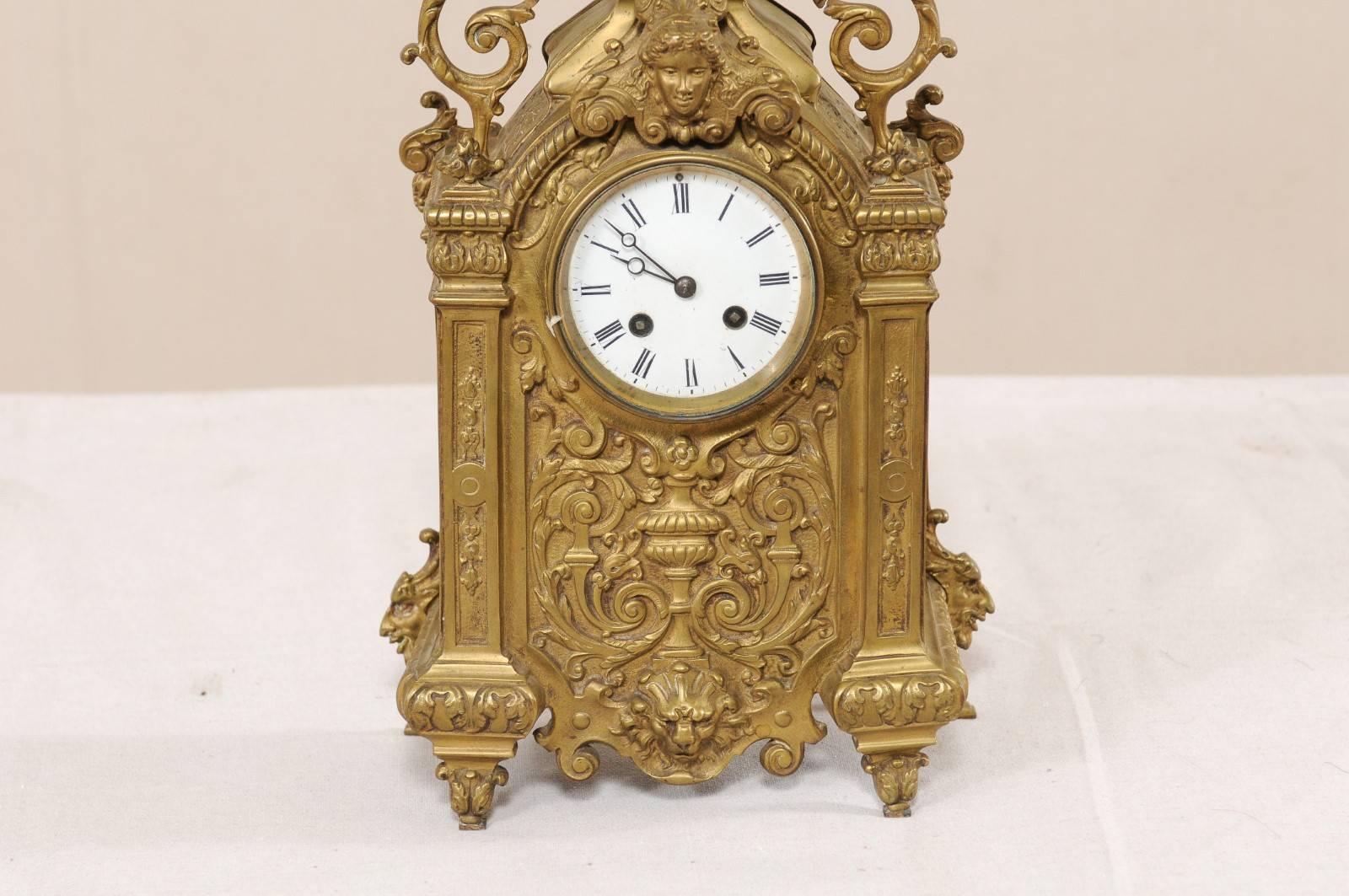 An ornately decorated French brass mantel clock from the turn of the 19th and 20th century. This antique French clock is exquisitely decorated on all sides, it has an overall scrolling foliage, acanthus leaf, and urn motif, with a pair of winged