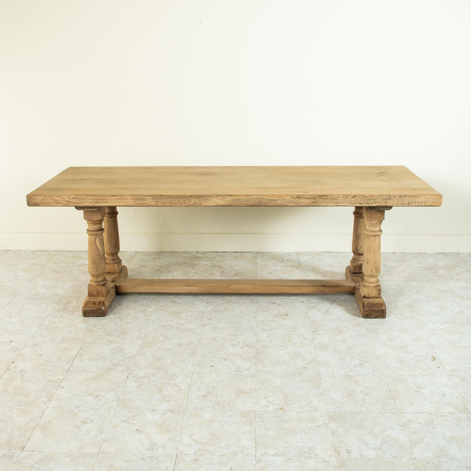 Found in the region of Normandy, France, this artisan-made oak farm table or dining table from the late nineteenth century features a 2.75 inch thick top constructed of four planks of wood. Three splines run the entire length of the table to join