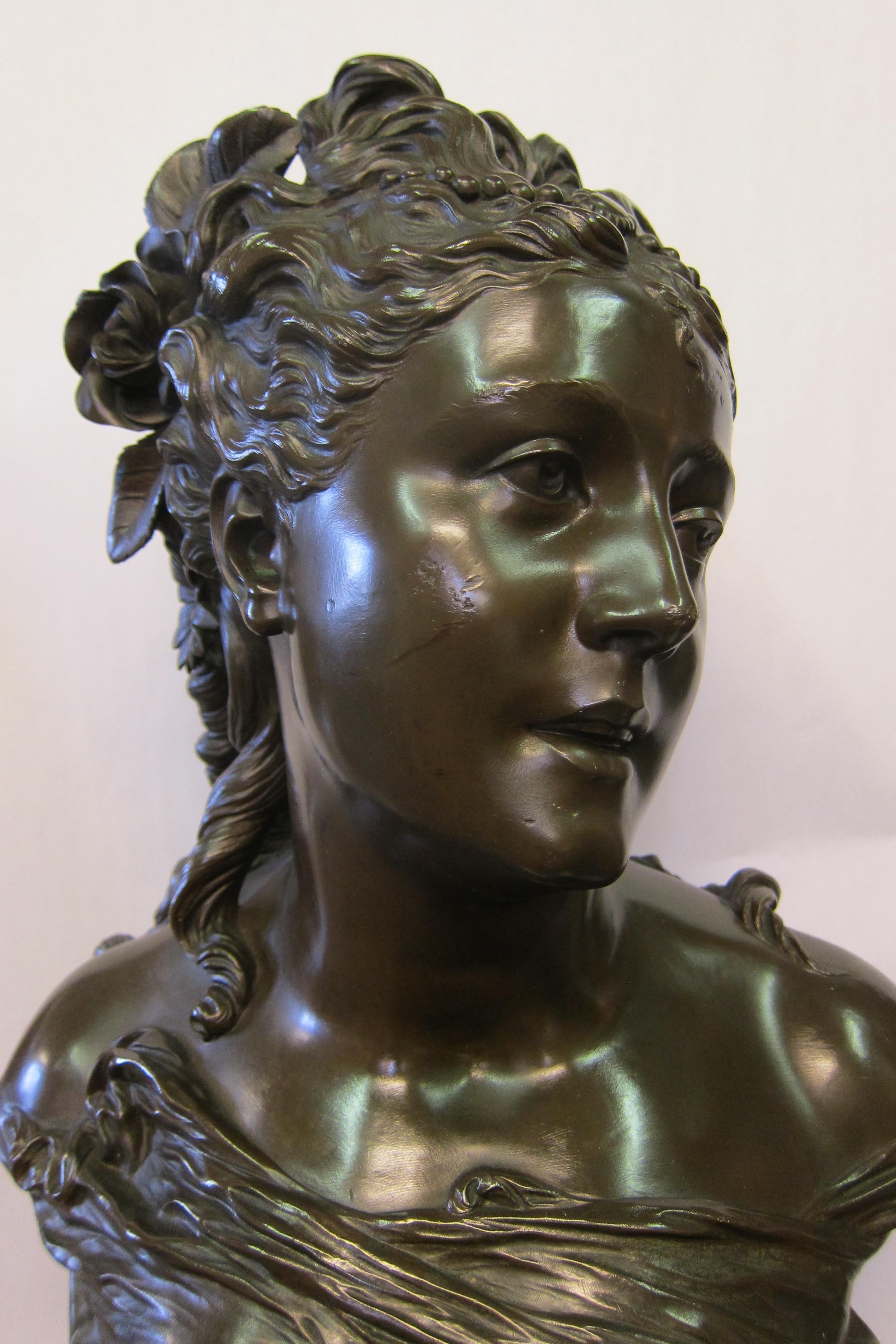 Cette sculpture vintage en bronze patiné, datant de 1890, représente un buste merveilleusement détaillé d'une belle dame parée de superbes fleurs dans ses cheveux. L'artiste, Pierre Louis Detrier (1822-1897), met en valeur son sujet avec des détails