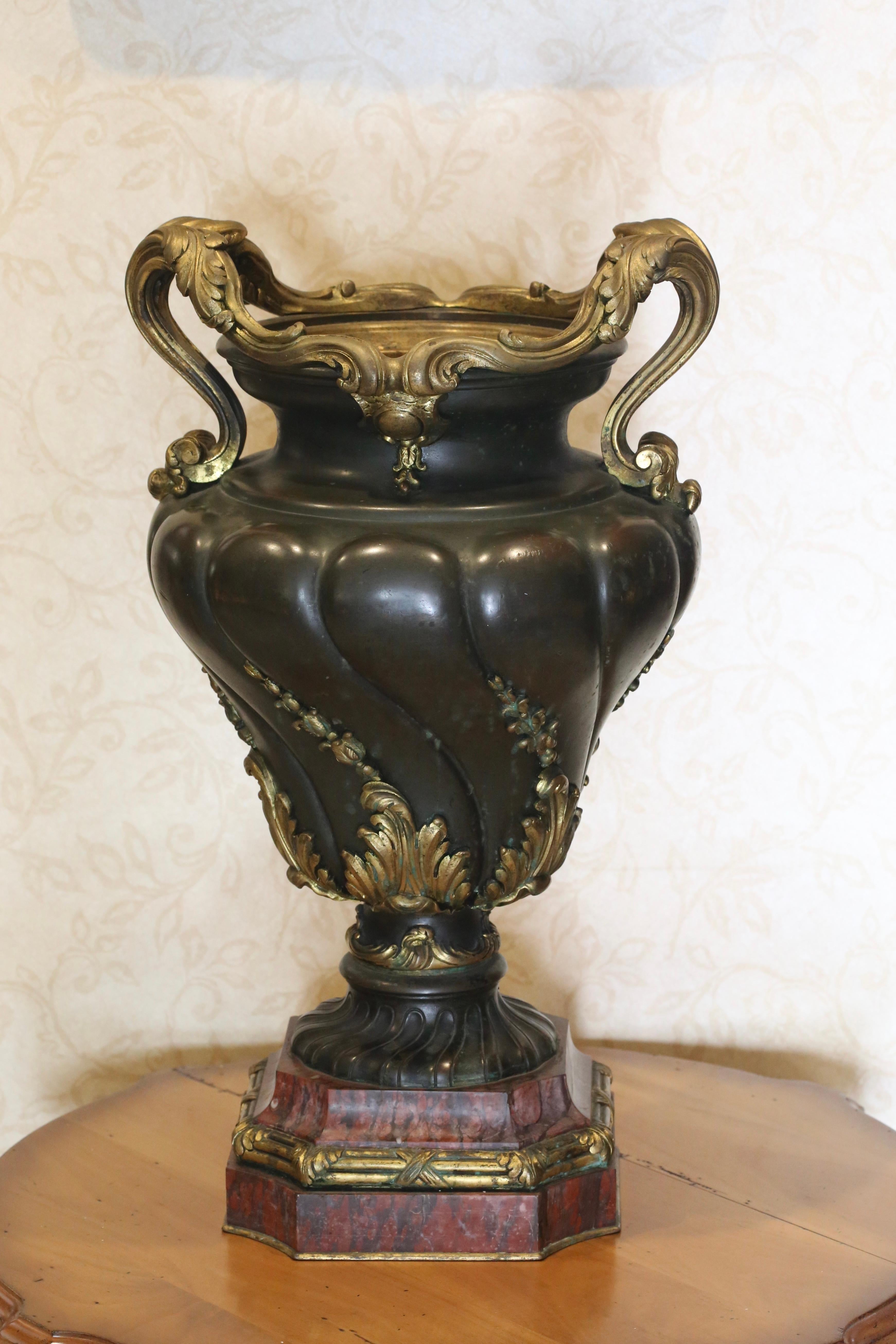 A very fine French gilt and patinated bronze urn, late 19th century

The foliate scroll handles above the spiral gadrooned body, on a shaped rouge griotte marble base

Auction record: London, South Kensington, Sale 6715, Christie's