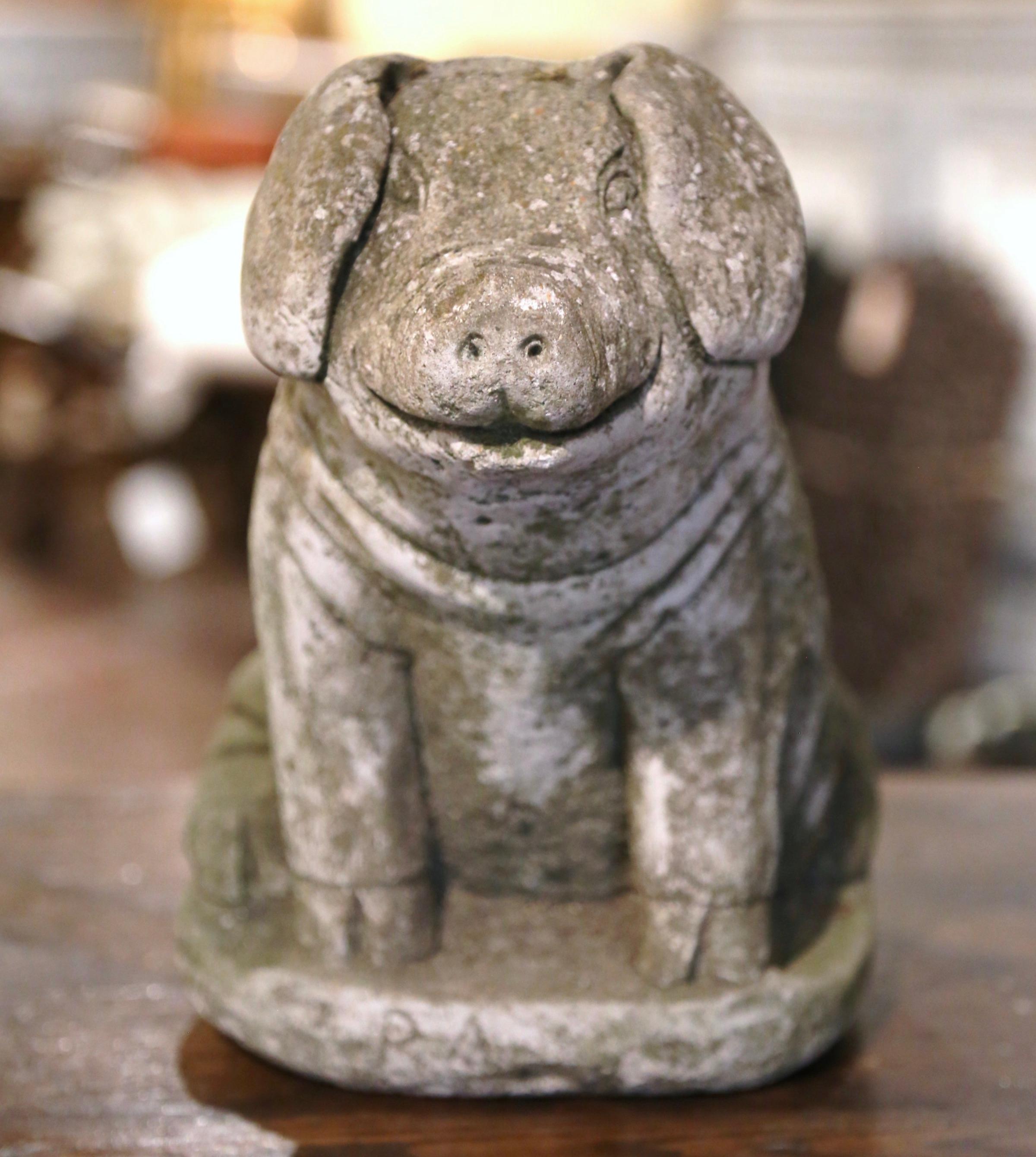 Decorate a kitchen counter or patio with this antique stone pig sculpture. Crafted in France circa 1890 and carved of concrete, the sculpture features a smiling pig sited on his back legs on a rocky oval base. The cheerful pig composition is in