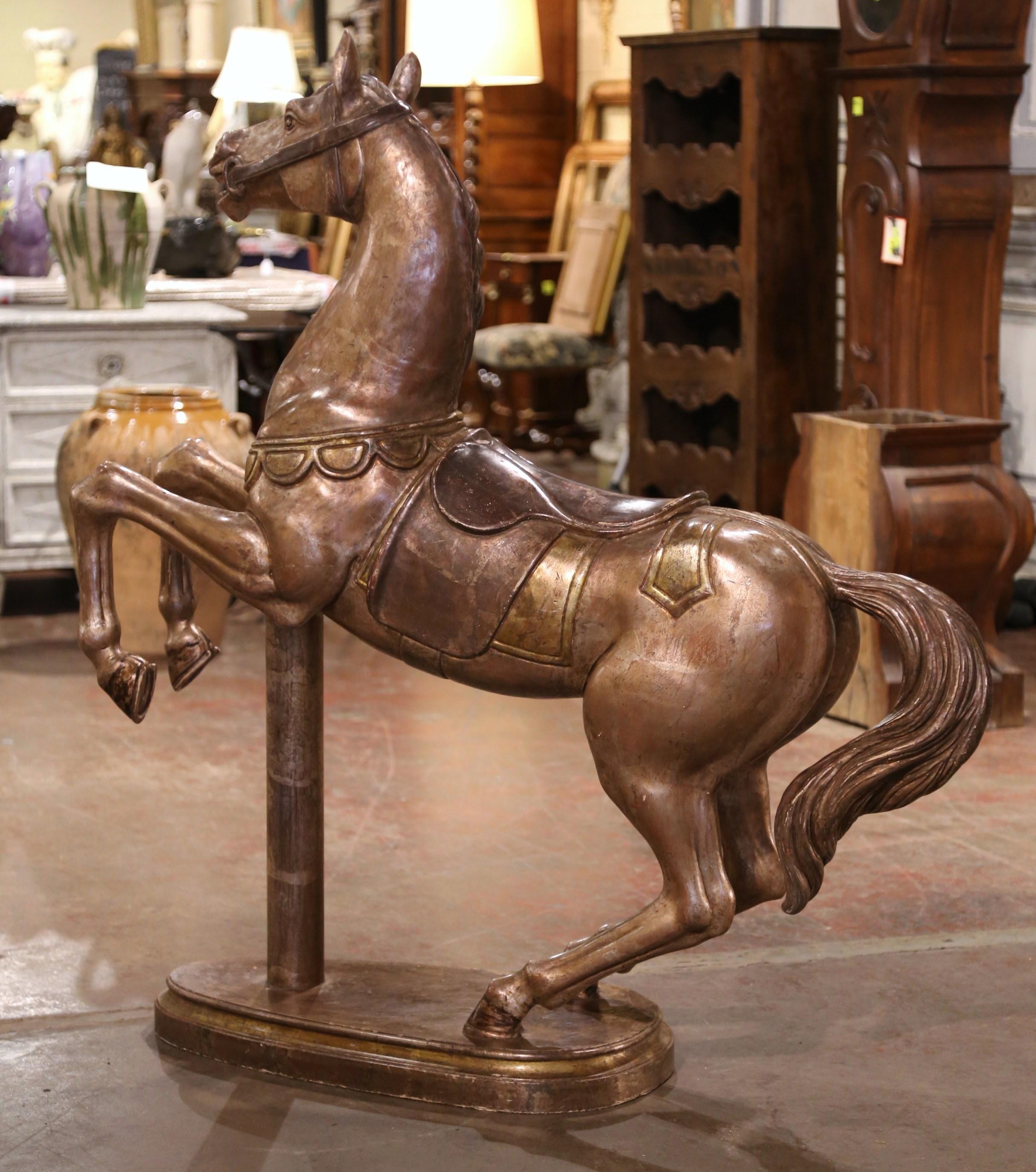 Crafted in France, circa 1880, this large, hand carved sculpture sits on an attached oval base; it features a horse figure rearing up on its back legs, fully tacked with English style saddle and bridle. The piece is further dressed with two ropes