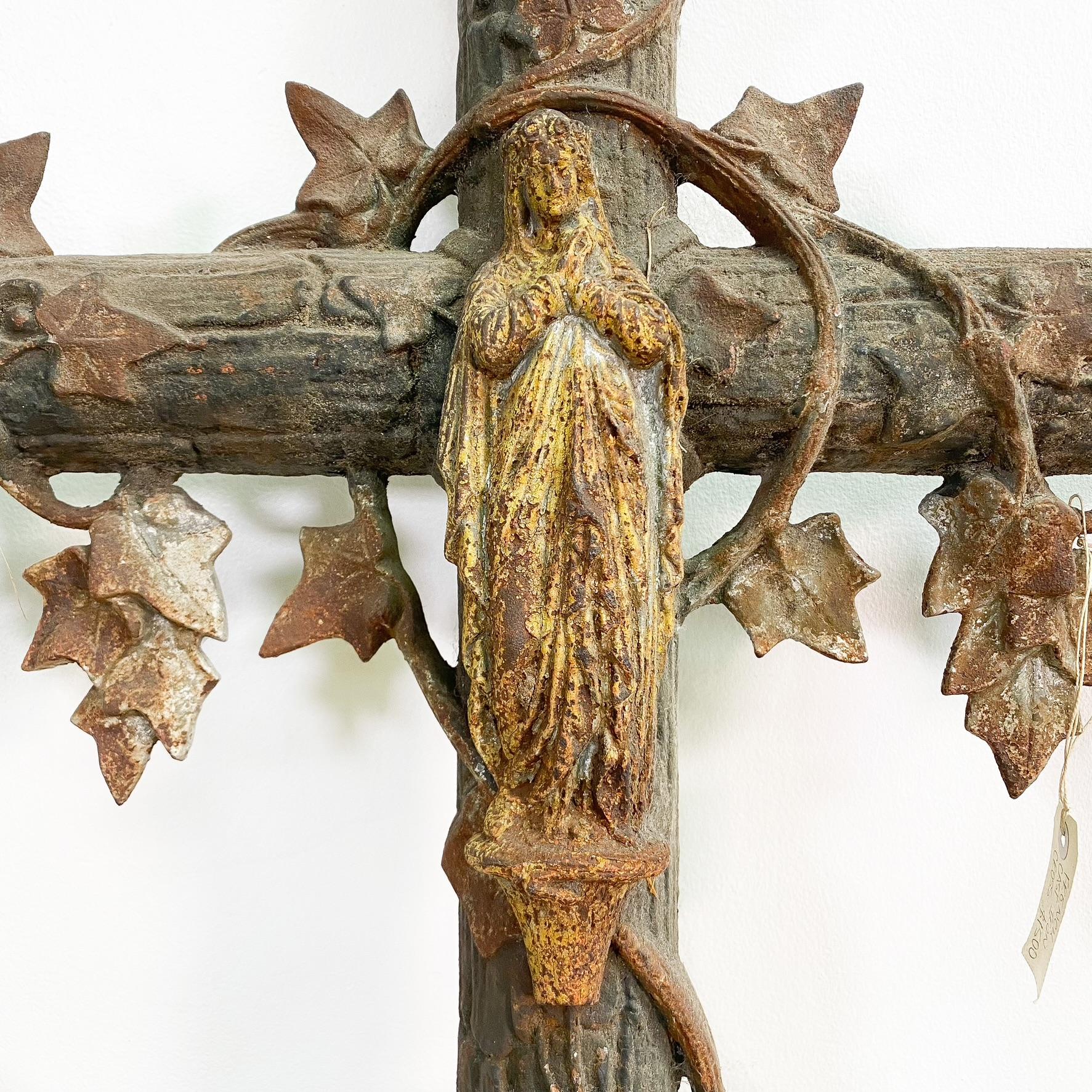 Wunderschönes großes antikes französisches Gusseisenkreuz aus dem späten 19. Jahrhundert. In der Mitte des Kreuzes befindet sich eine Marienfigur, und der Guss des Blattwerks ist von hervorragender Qualität. Tolle Patina mit leichtem Oberflächenrost