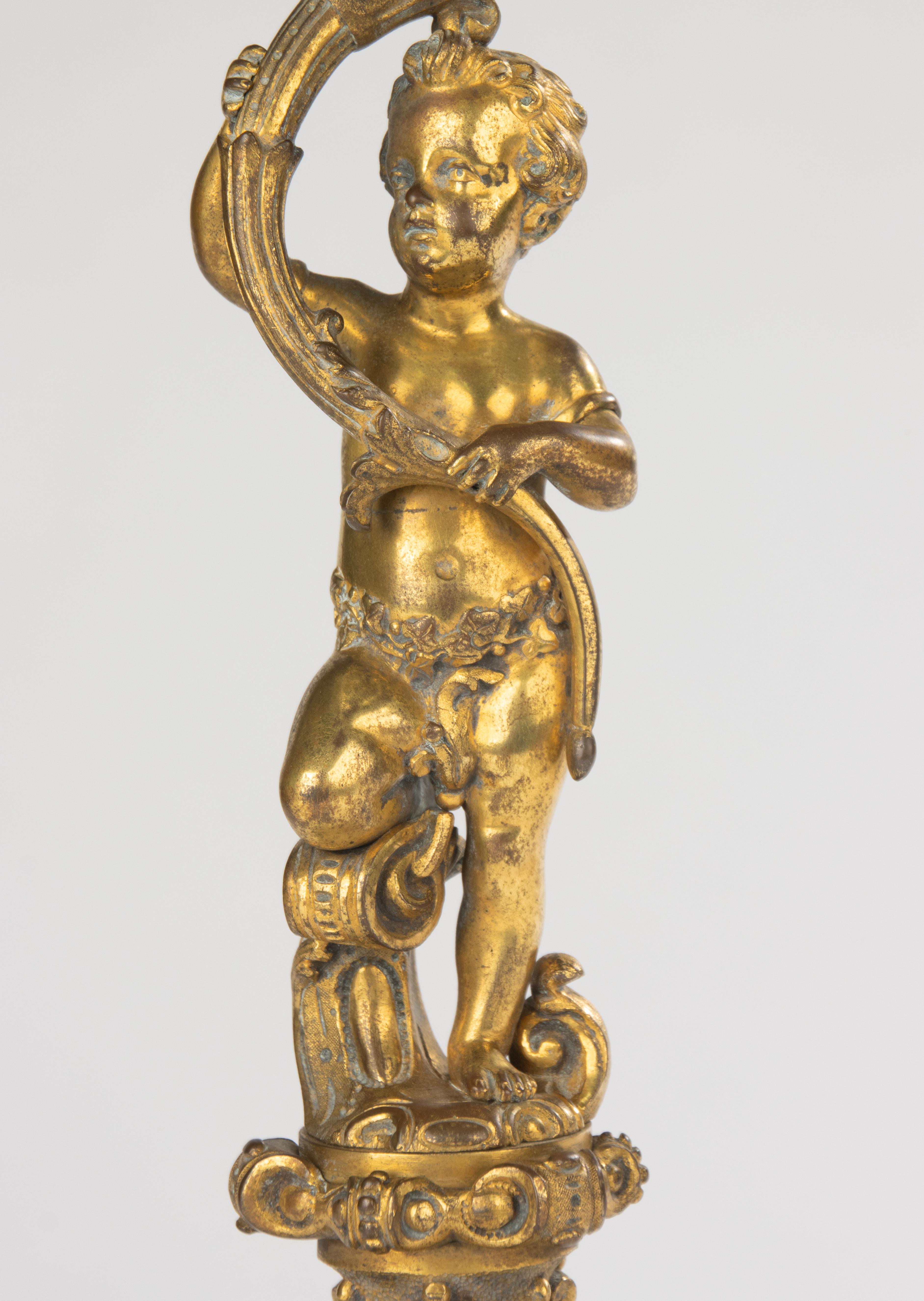 Elegant 19th century French centerpiece, finely cast in bronze with gilt patina, featuring a putto holding a beautifully cut crystal dish. The richly decorated base shows intricate scrollwork and mask motifs, typical of the opulent French decorative