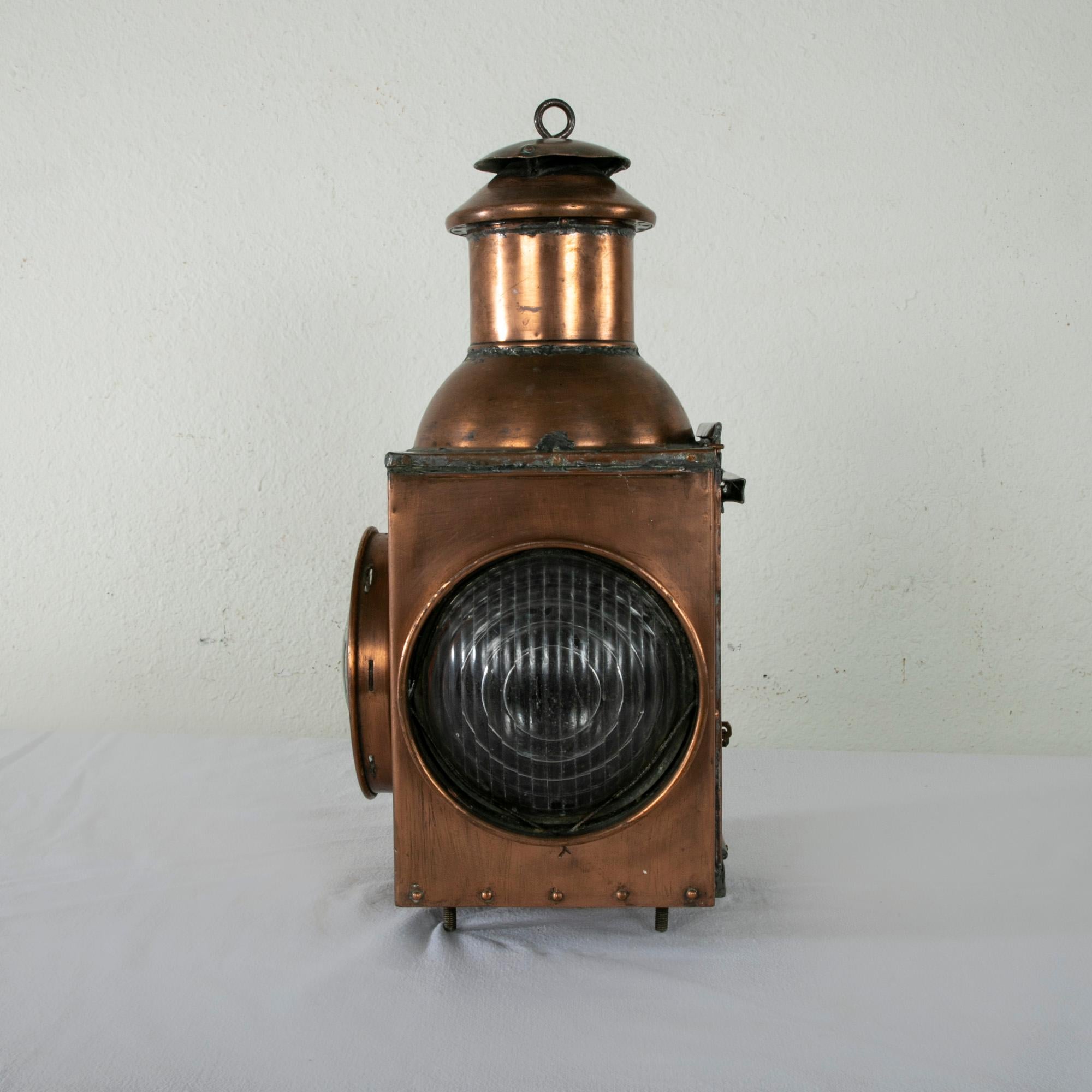 Originally used for signaling, this French copper railroad lantern from the late nineteenth century features glass on two sides one of which is tinted orange. A door on one side is stamped with the number 11 and slides up to allow access to the