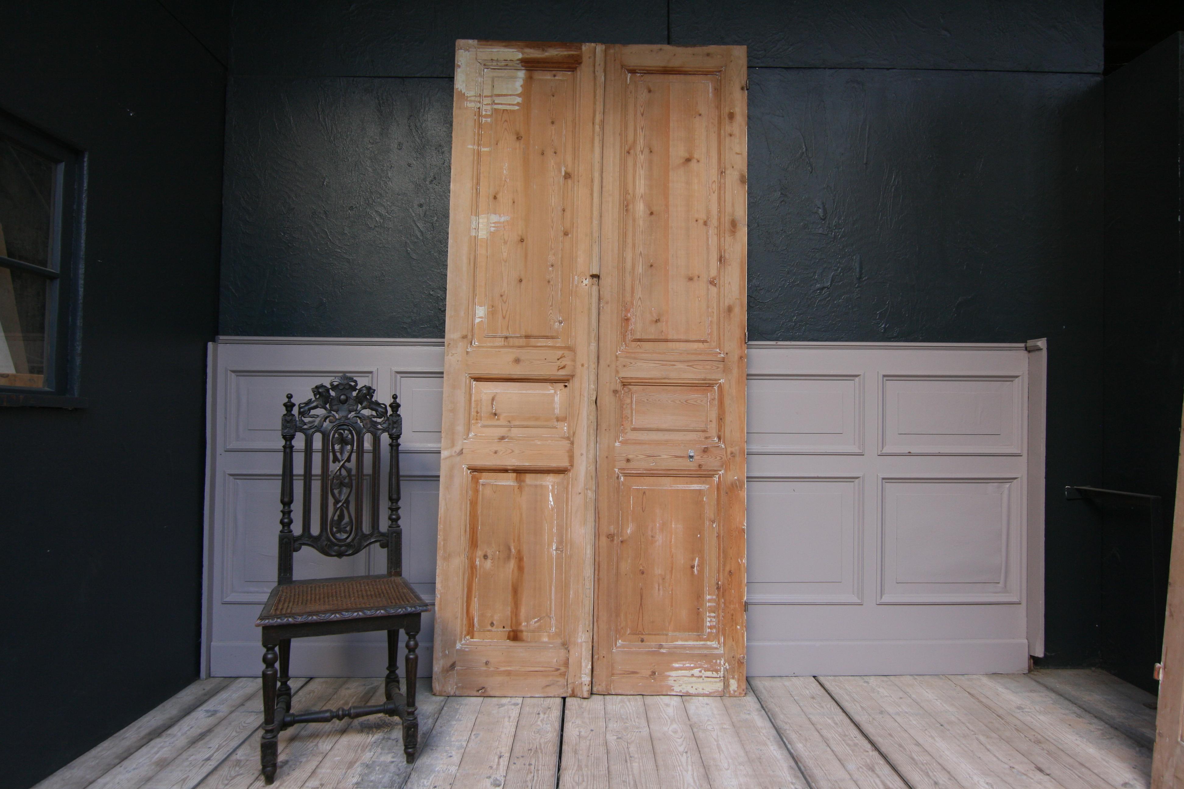 A late 19th century French double door made of pine.
The doors were mostly stripped of the old paint but are in unrestored condition. 

Dimensions: 
245 cm high or 96.46 inch high, 
55 / 57.5 cm / 110 cm (together) wide or 21.65/ 22.64 inch /