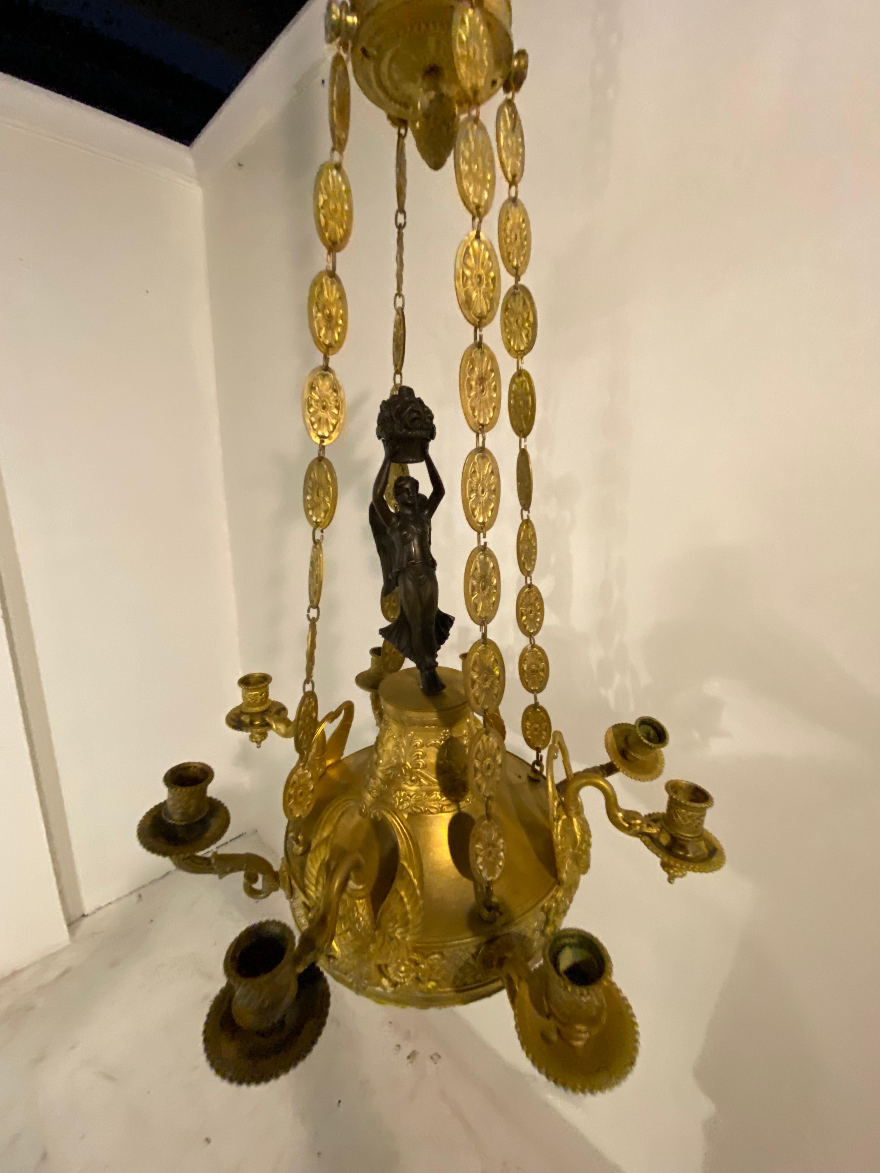 a late 19th Century French Empire chandelier with swam head's. Original finish and patina.