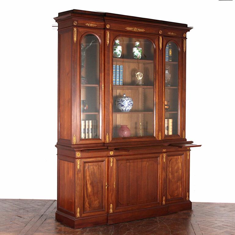 Very large French solid mahogany Empire style bookcase with three upper glazed arched doors and lower solid mahogany paneled doors, the case accented throughout with fine ormolu mounts. C. 1900

