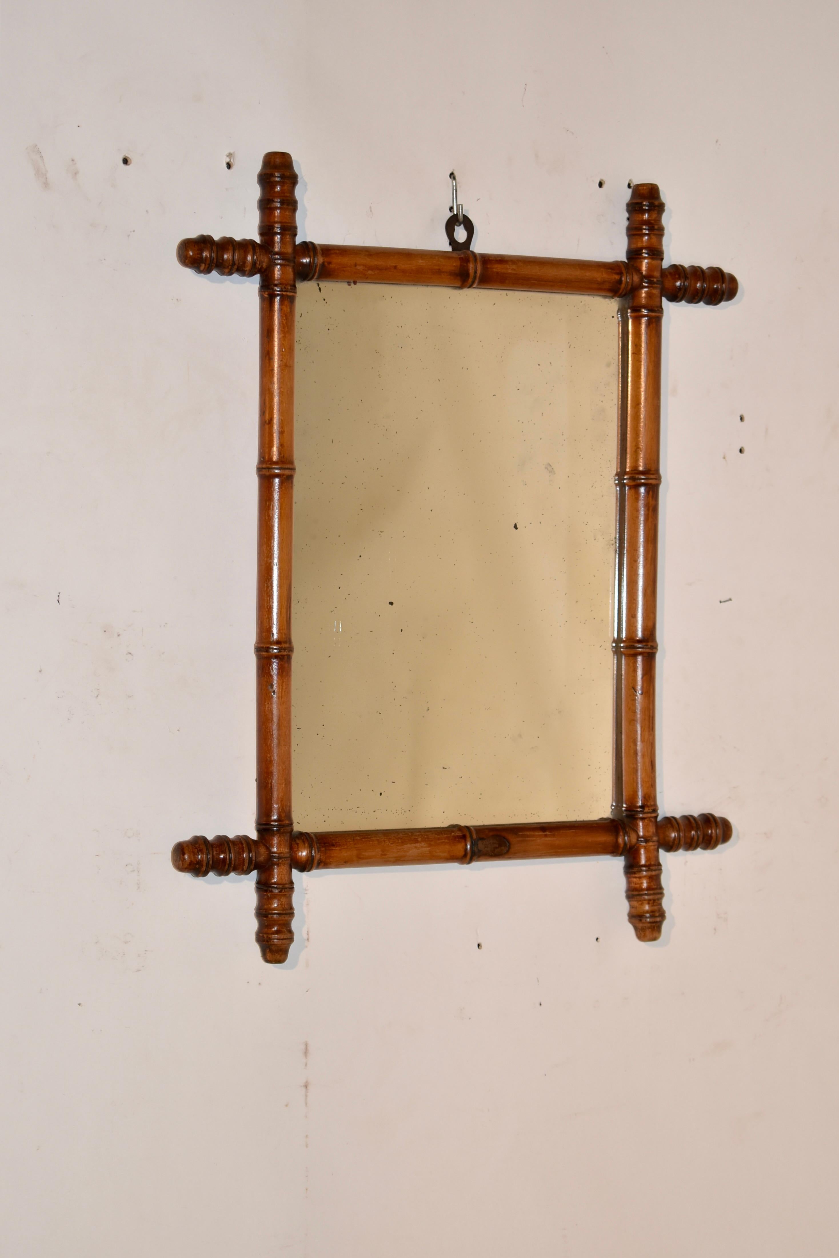 Late 19th century faux bamboo mirror made from cherry in France.  The frame is hand turned to have the appearance of bamboo, but is made from rich cherry and retains its original color and patina.  The corners of the frame intersect and surround a