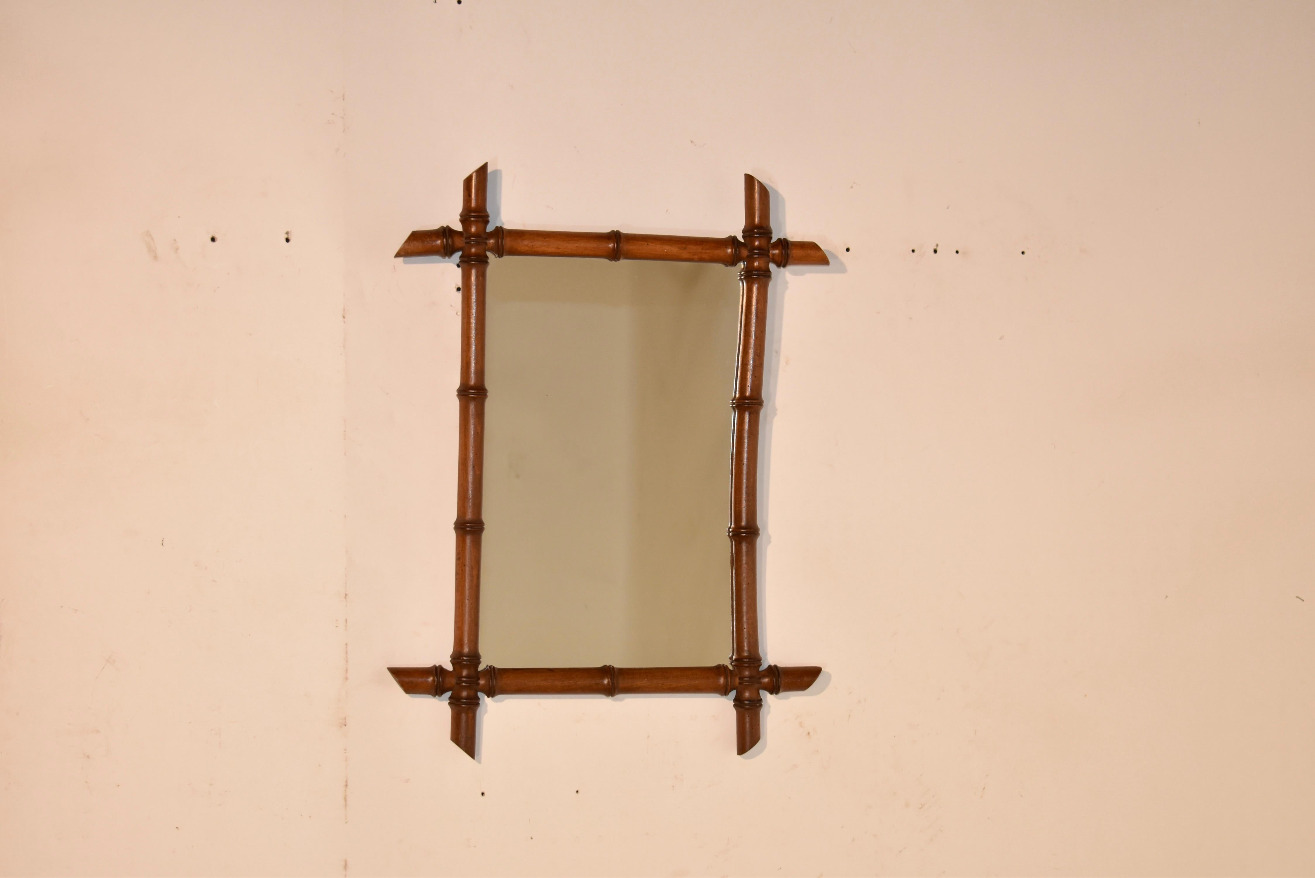 Miroir mural en faux bambou de la fin du 19e siècle en France.  Le cadre est tourné en cerisier et ressemble à du bambou.  Le cadre entoure un miroir.  Ces miroirs s'intègrent parfaitement à tous les styles de décoration.