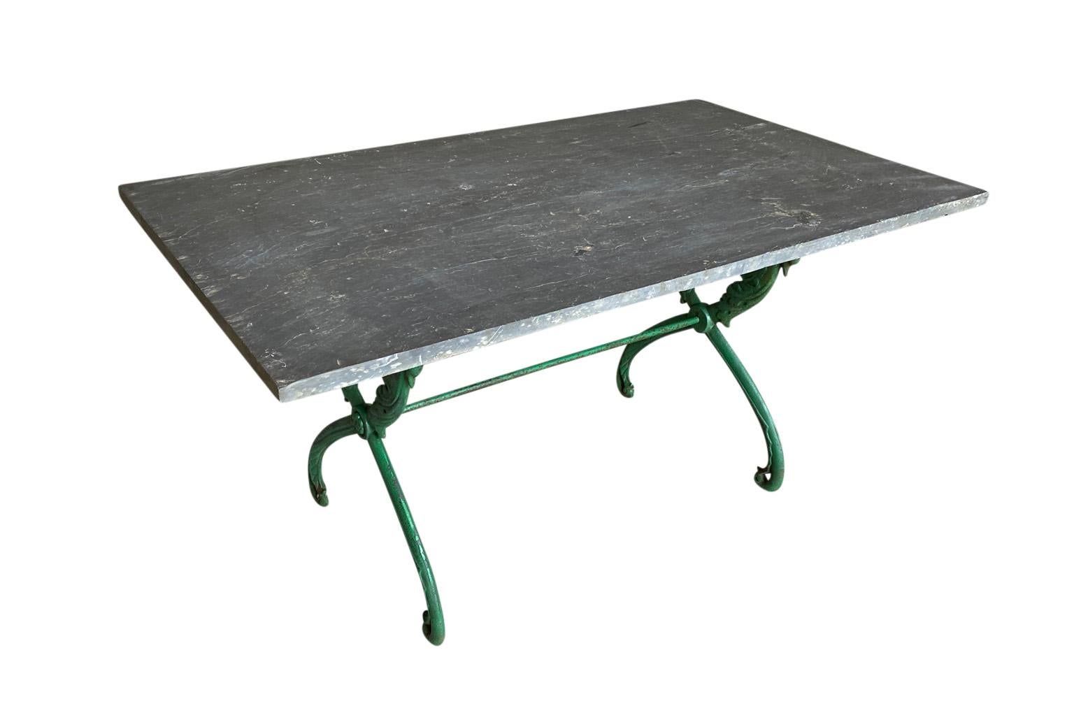 A very lovely later 19th century garden table from the South of France beautifully constructed with a painted iron base and stone top. The legs are decorated with lovely swans. Perfect for any interior or exterior environment.