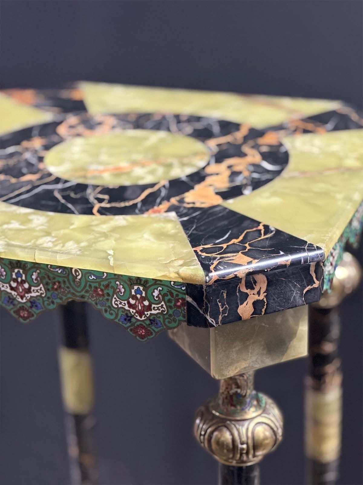 Ein exquisiter französischer Sockeltisch aus dem späten 19. Jahrhundert, gefertigt aus reich geädertem grünem Onyx und schwarzem Marmor, verziert mit detaillierten Cloisonné-Emaille-Akzenten. Die achteckige Platte weist eine auffällige geometrische
