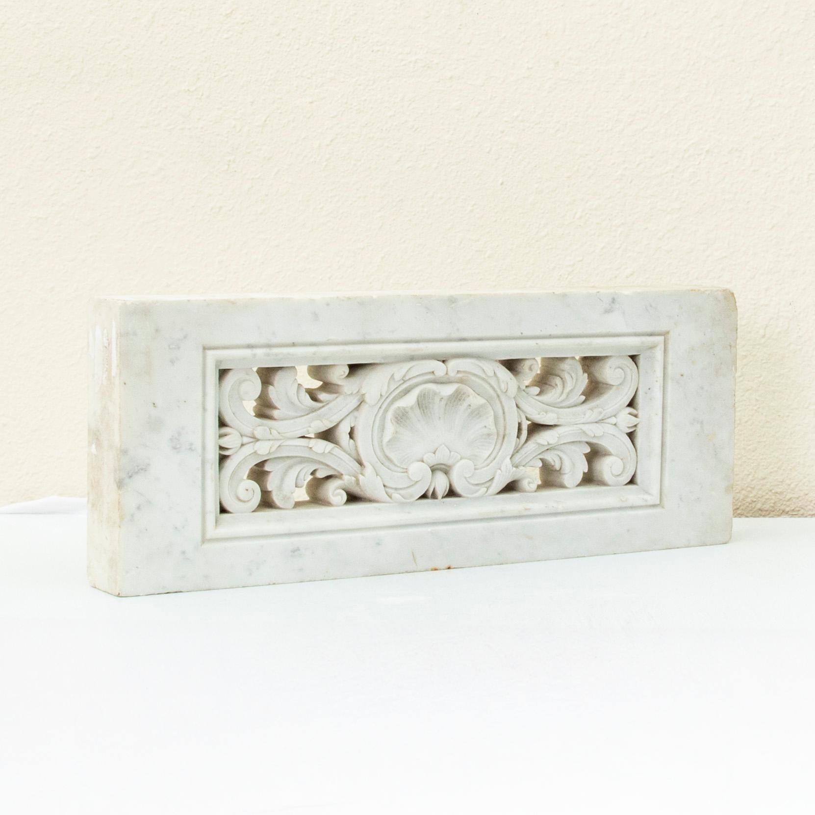 Cet élément architectural français de la fin du XIXe siècle est sculpté à la main dans une seule pièce de marbre et présente une coquille centrale festonnée flanquée de feuilles d'acanthe en relief. Le motif central est entouré d'une bordure