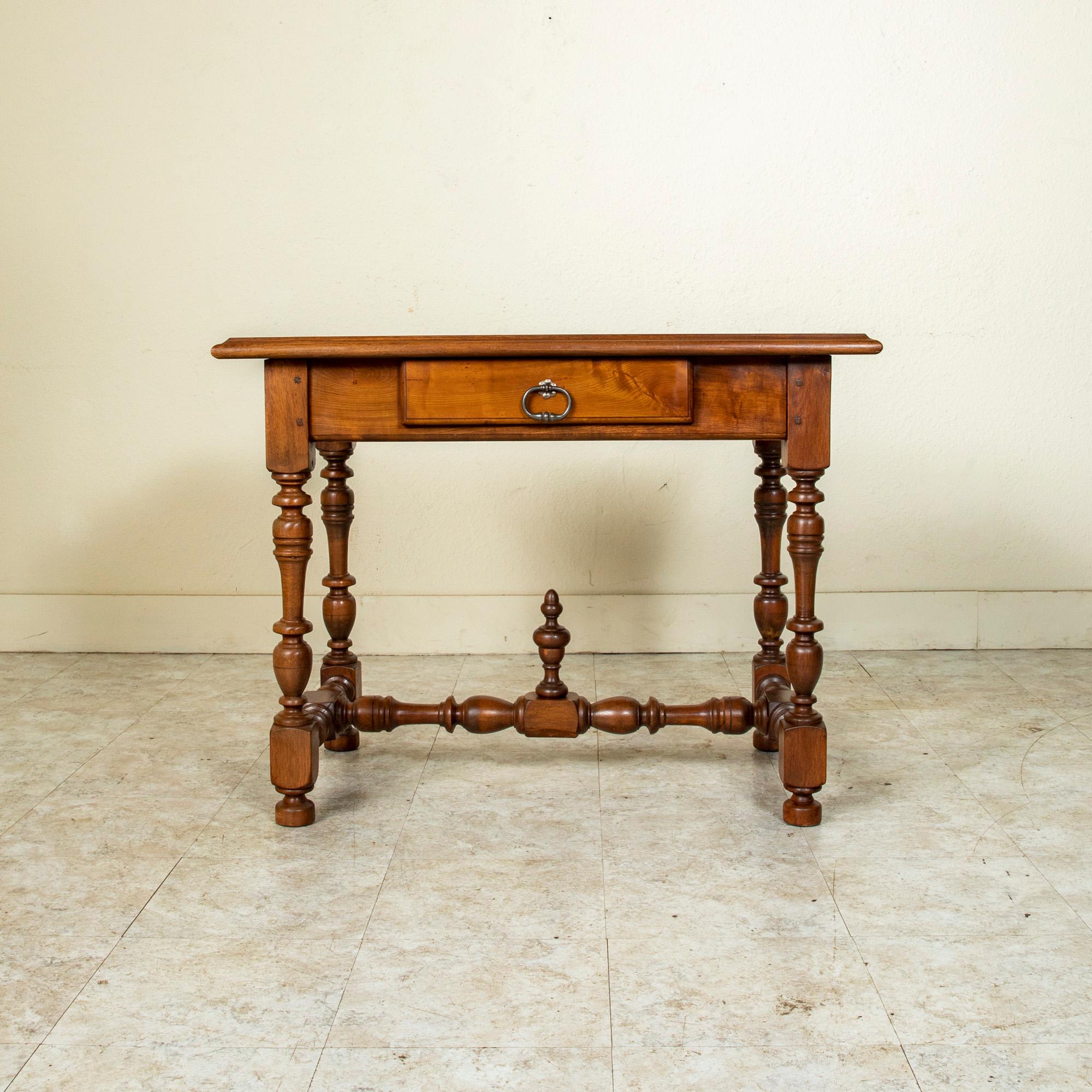 This late 19th century French Henri II Renaissance style hand pegged walnut writing table or side table is finished on all sides, allowing it to be placed in the center of a room. Its beveled top rests above a single drawer of dovetail construction
