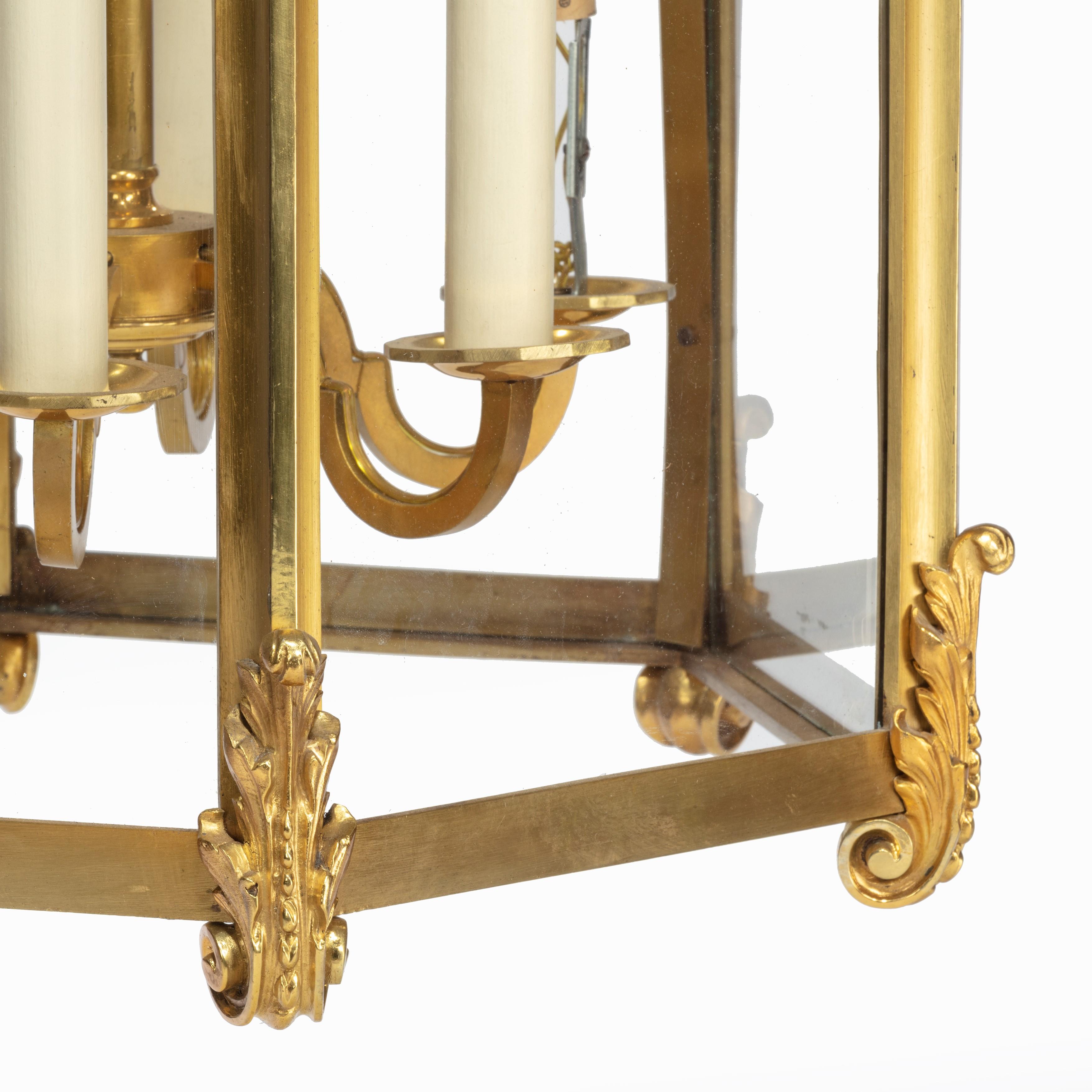 A late 19th century French hexagonal ormolu hanging lantern, each of the six glazed sides enclosed within scrolling foliate mounts centred on a tri-lobed palmette, re-wired for electricity.