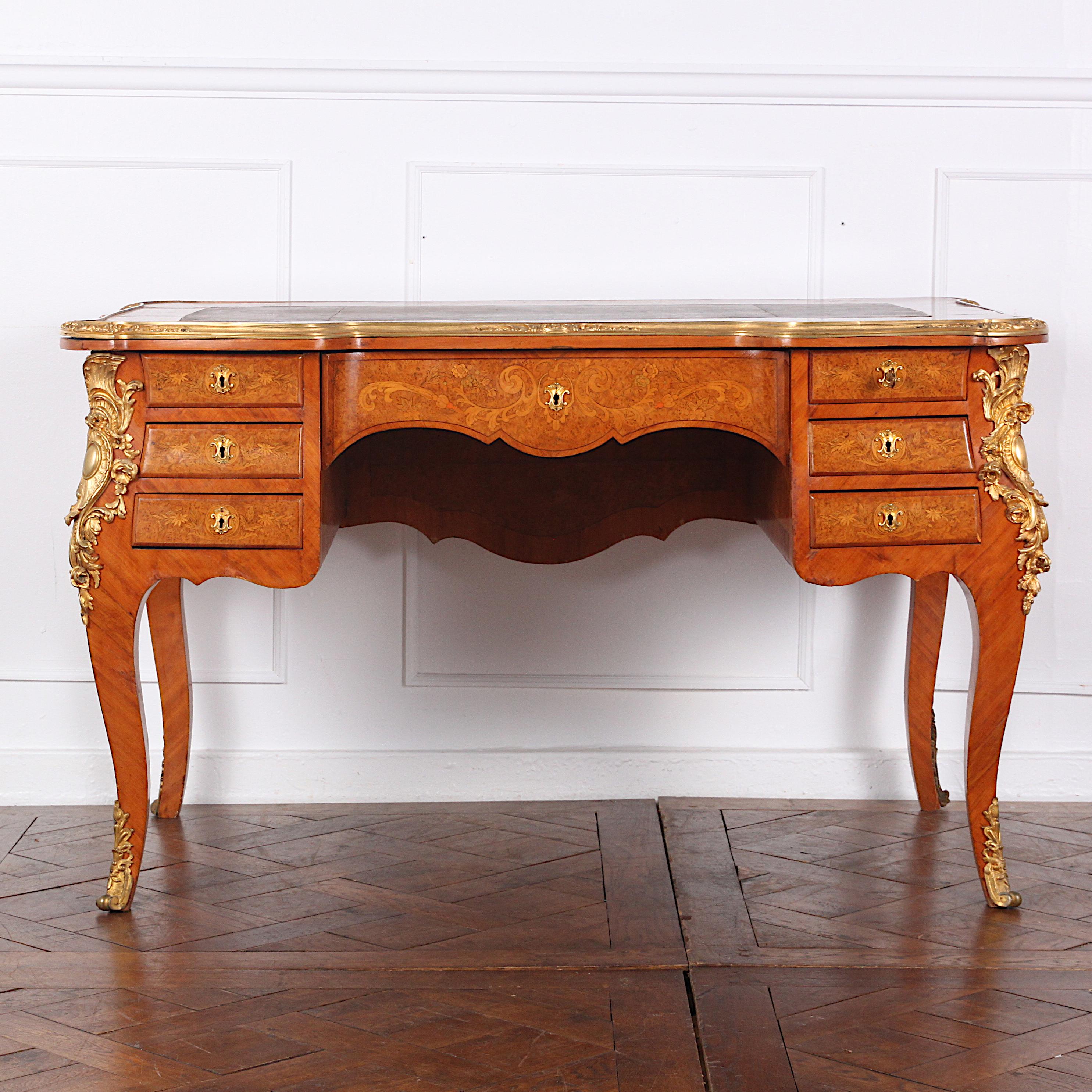 Highly inlaid French Louis XV style desk or ‘bureau plat’ in kingwood, bird’s-eye maple, burl walnut, fruitwood etc. Highly detailed floral marquetry panels to the sides and back with similar marquetry work to the seven-drawer fronts. The desk is