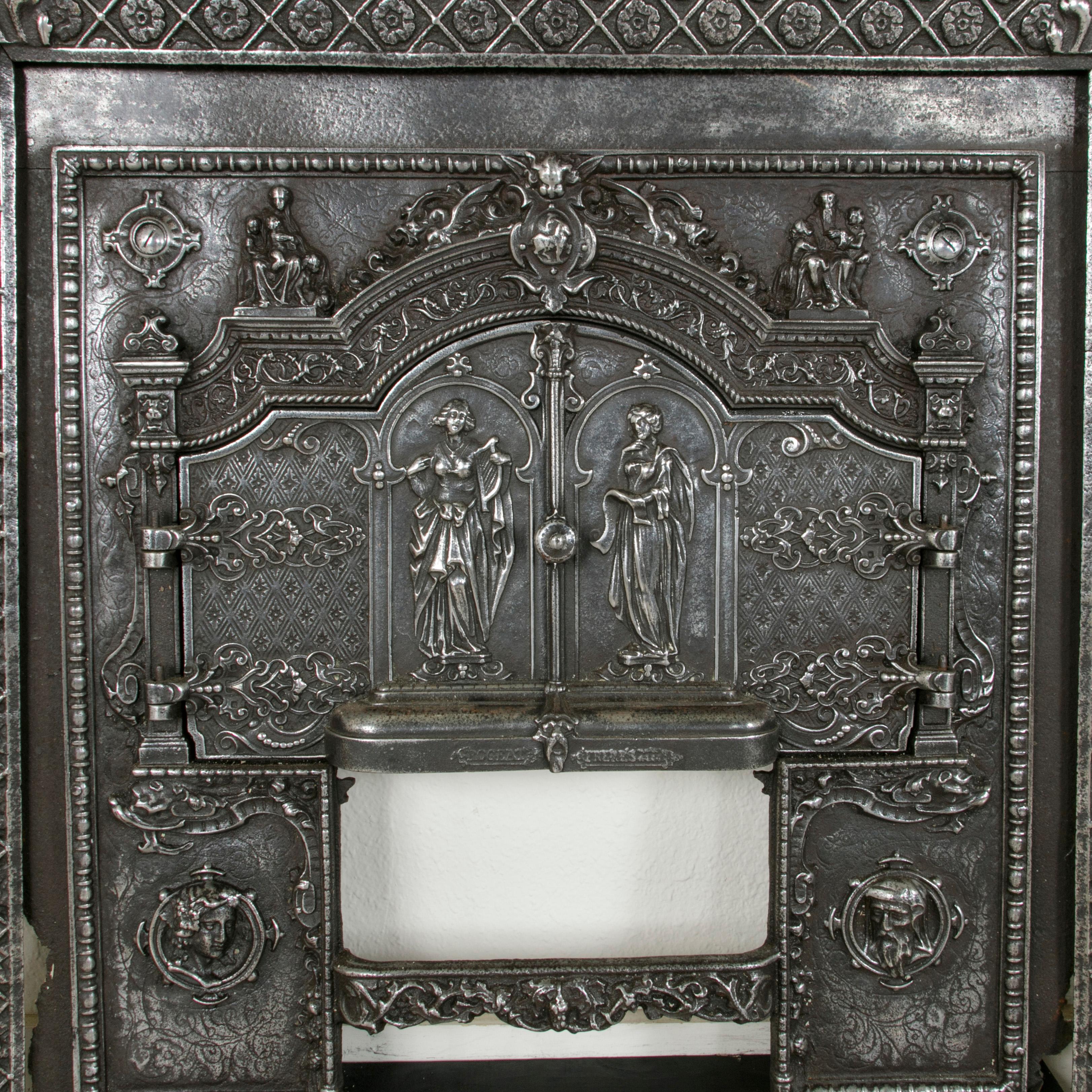 This impressive late 19th century French cast iron fireplace surround insert features two double faced hinged doors with deep relief female figures on both sides. Below the doors are male and female profile busts that flank a central bar in the