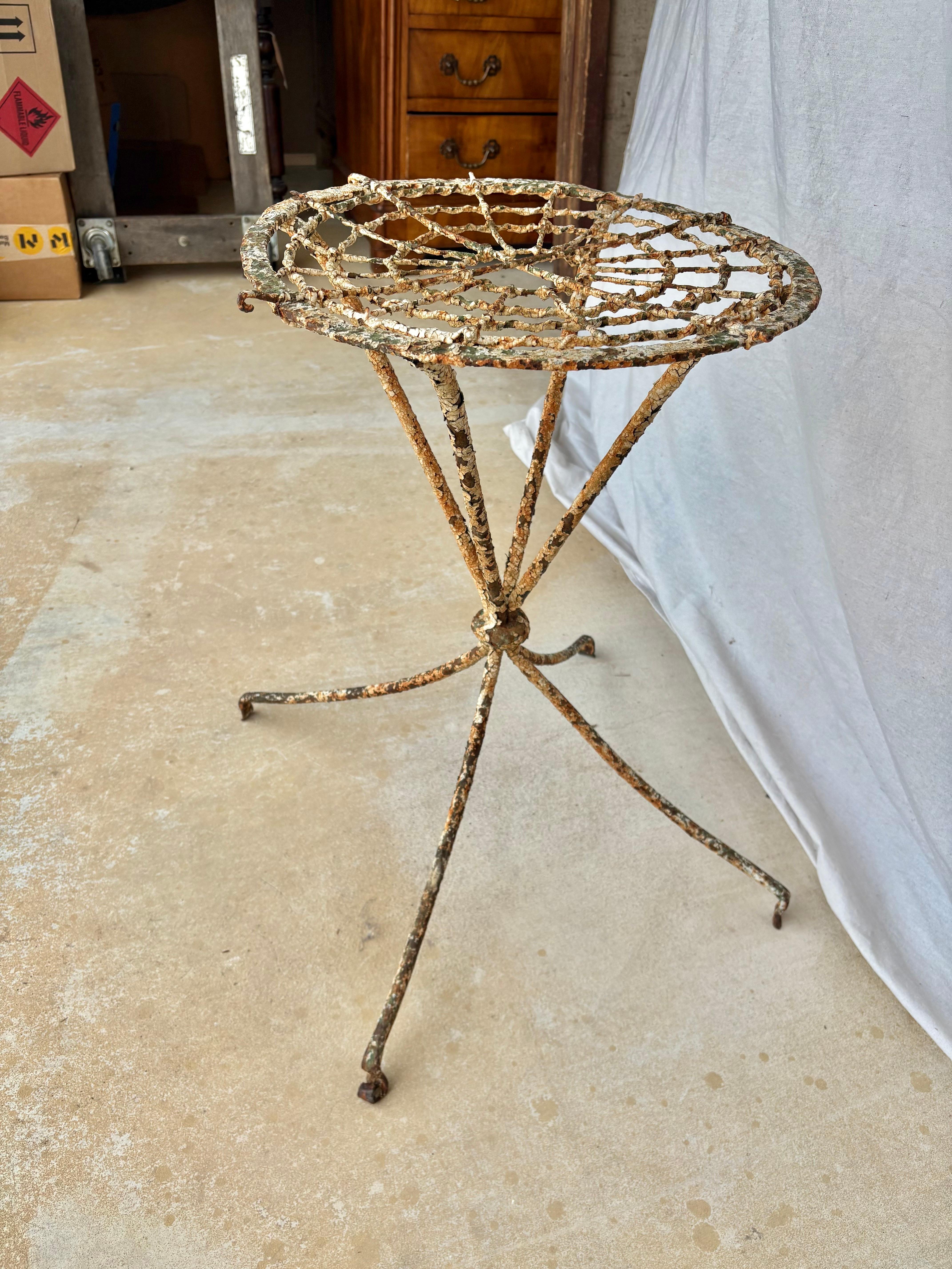 Trouvée dans le sud de la France, cette table de jardin du XIXe siècle a été fabriquée à la main en fer par des artisans français à la fin des années 1800. Cette table est dotée d'un plateau rond à structure palmée reposant sur quatre pieds évasés