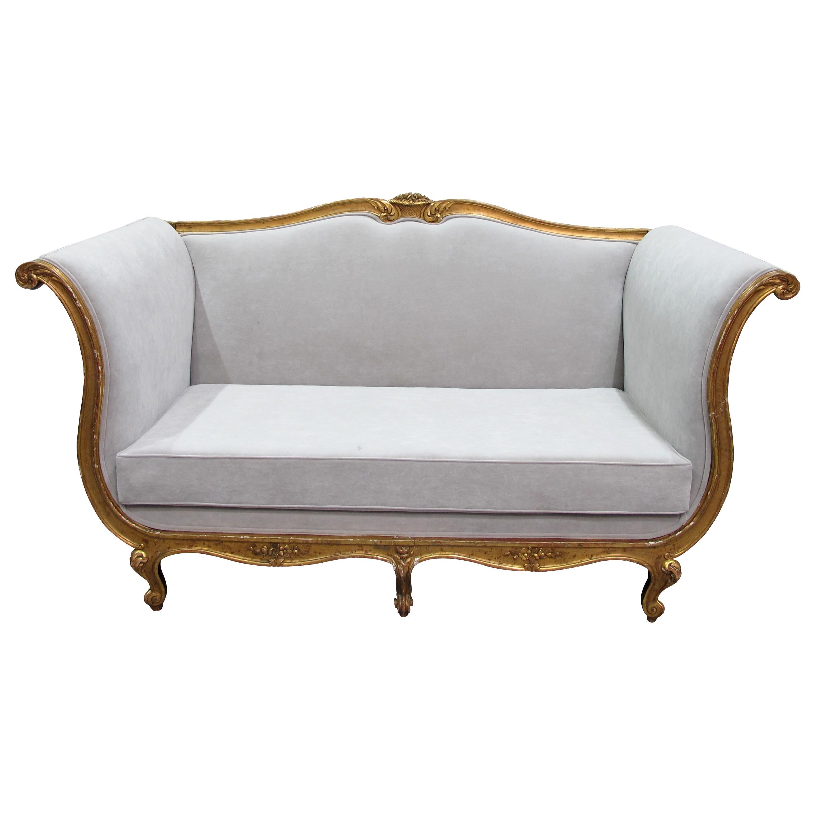This is a very large and comfortable 19th-century sofa, newly upholstered with a hardwearing washable suede-like light grey fabric. This style of furniture was popular during the reign of King Louis XV of France. It is characterized by its curvy