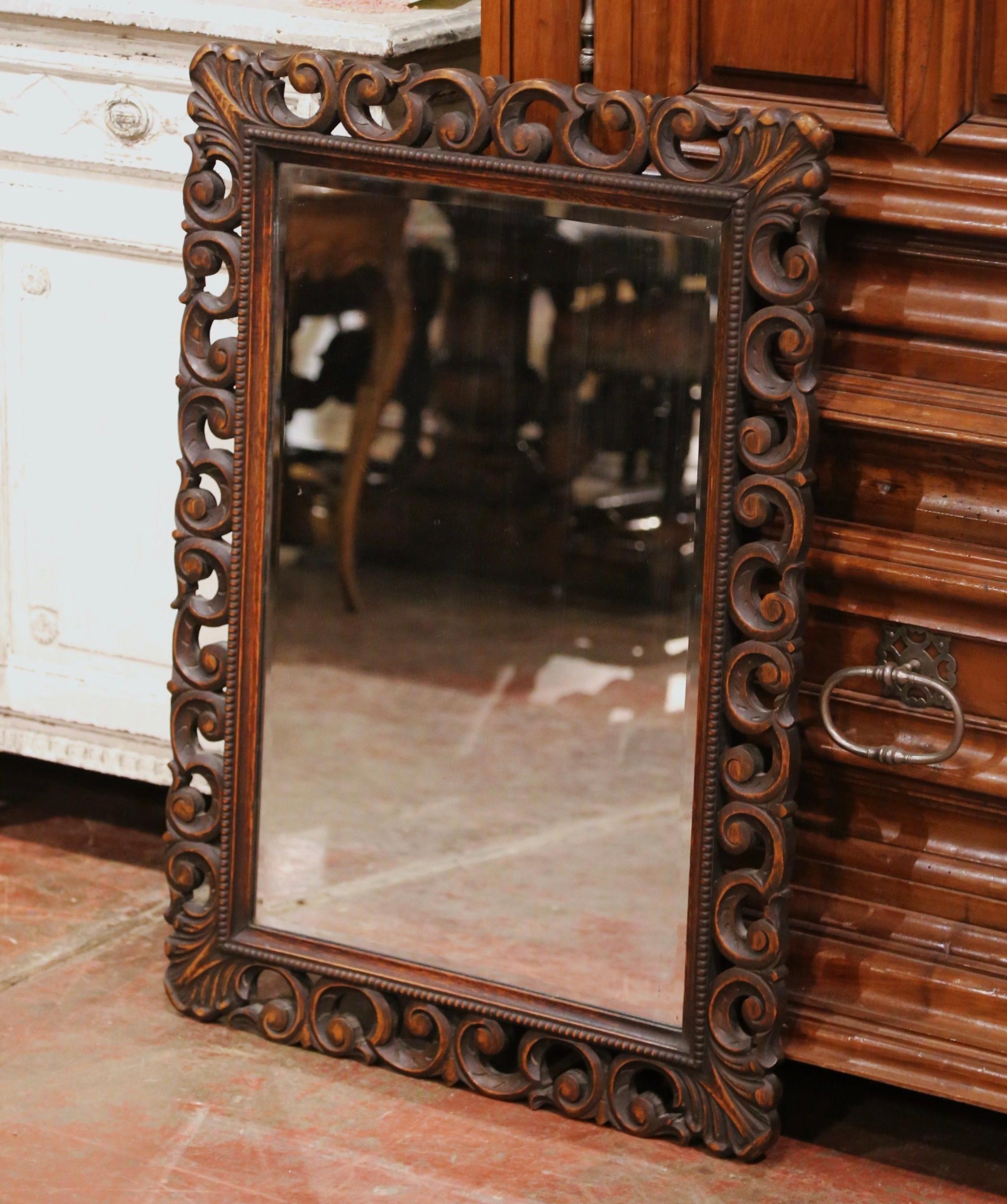 Crafted in France circa 1890, and built of oak wood, the antique mirror is rectangular in shape and could be hang vertically or horizontally. The frame with beads, is decorated with pierced hand carved acanthus leaf and floral motifs throughout and