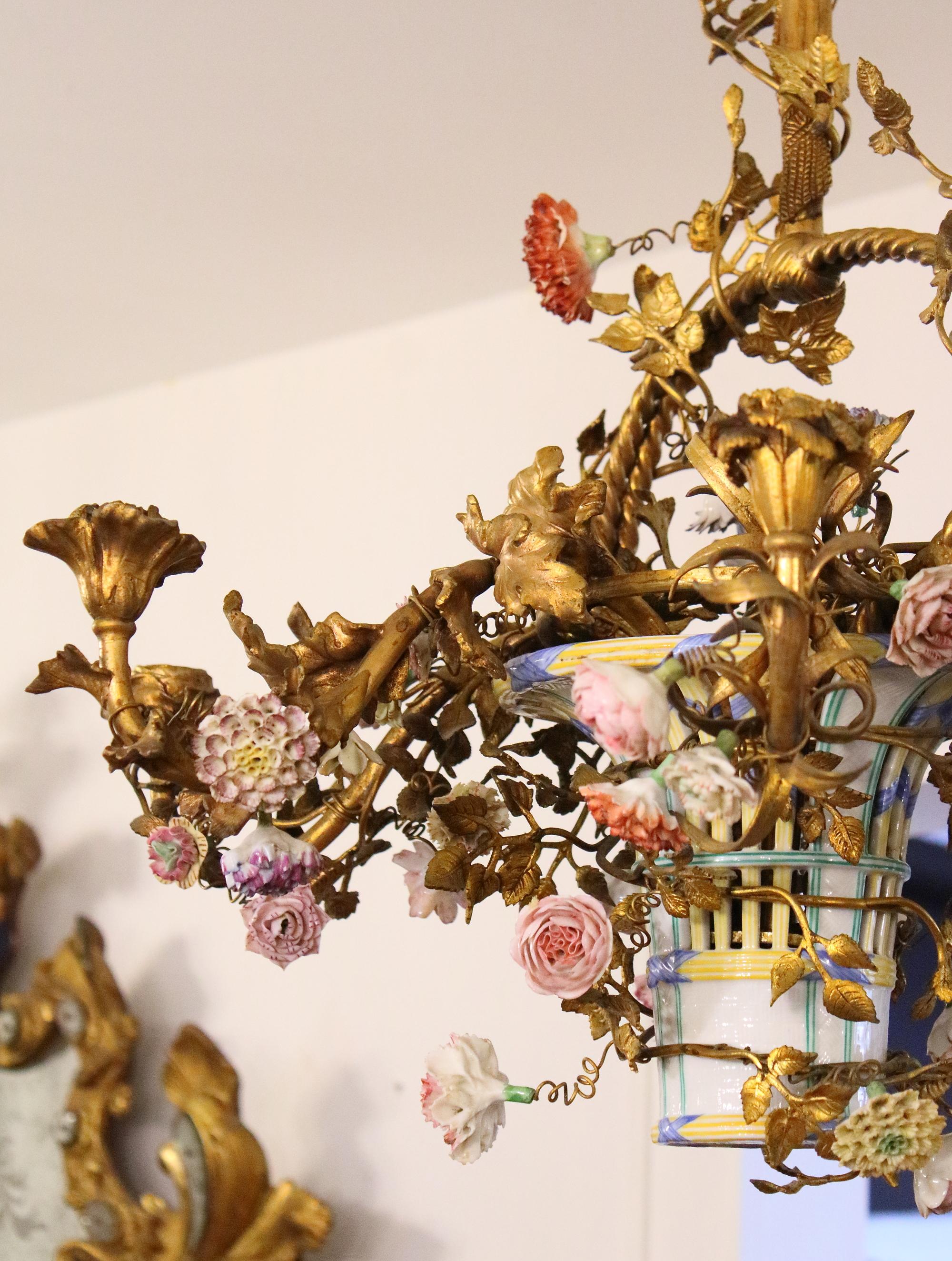 Late 19th Century French Louis XV Style Gilt Bronze Porcelain Flowers chandelier

Charming Louis XV style gilt bronze chandelier with six candle branches and a central porcelain vase/basket placed in the center of the chandelier frame. The