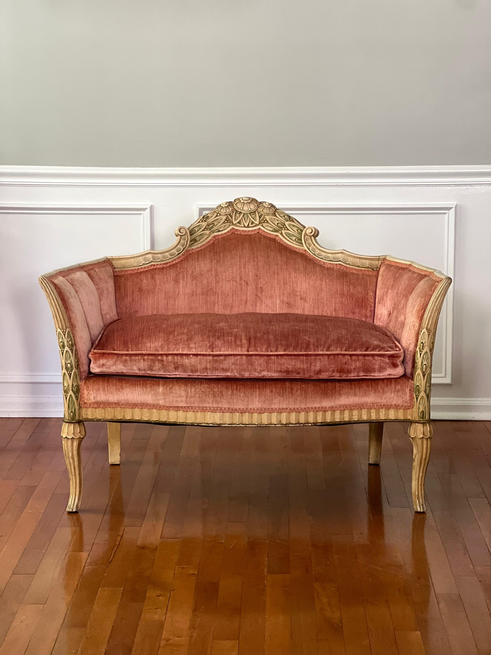 Antique soft coral pink velvet settee with paint decorated, carved wood frame, France, circa 1880.  Beautiful design with flared sides and back and a superbly carved wood frame with floral and leaf detail with geometric motif trim.  The frame is