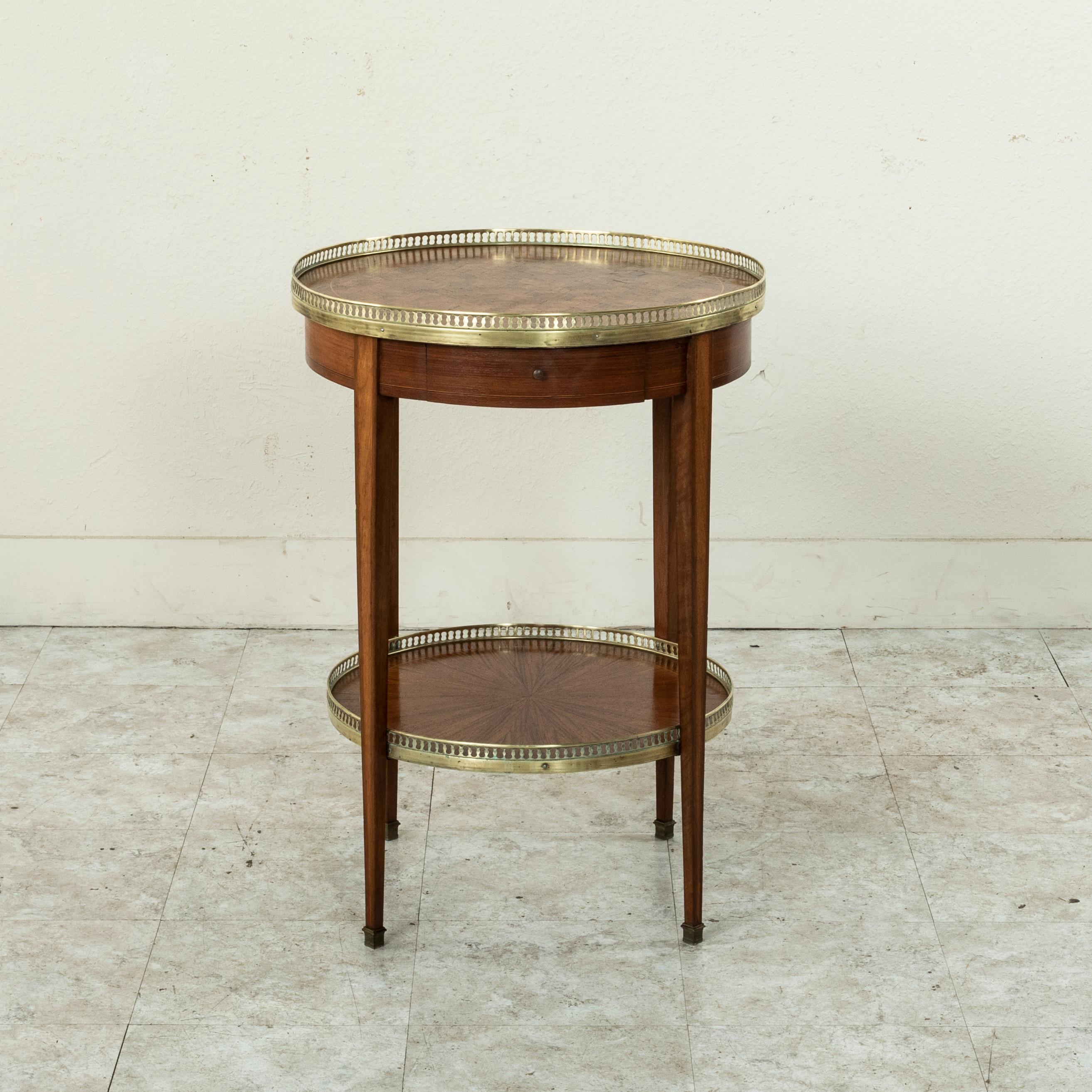This late nineteenth century French gueridon or side table in the Louis XVI style features an inlaid rosewood top in a geometric pattern surrounded by a pierced bronze gallery. The apron is fitted with a single drawer and is detailed with fine lines