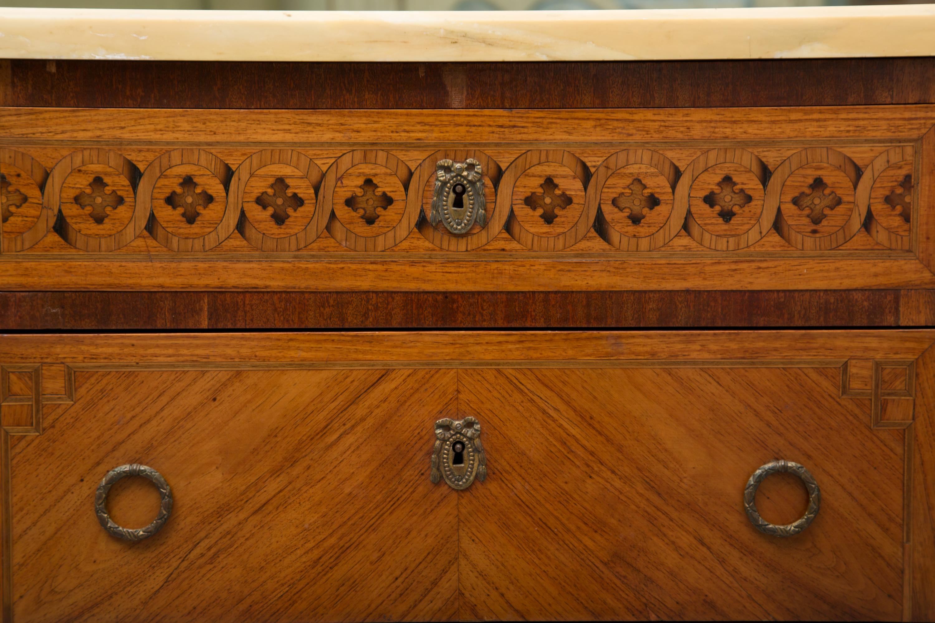 Charmante commode en bois de tulipier de la fin du XIXe siècle, de style Louis XVI, avec un plateau en marbre jaune ocre surmontant un tiroir à frise incrustée situé au-dessus de deux longs tiroirs, le tout reposant sur des pieds carrés fuselés.