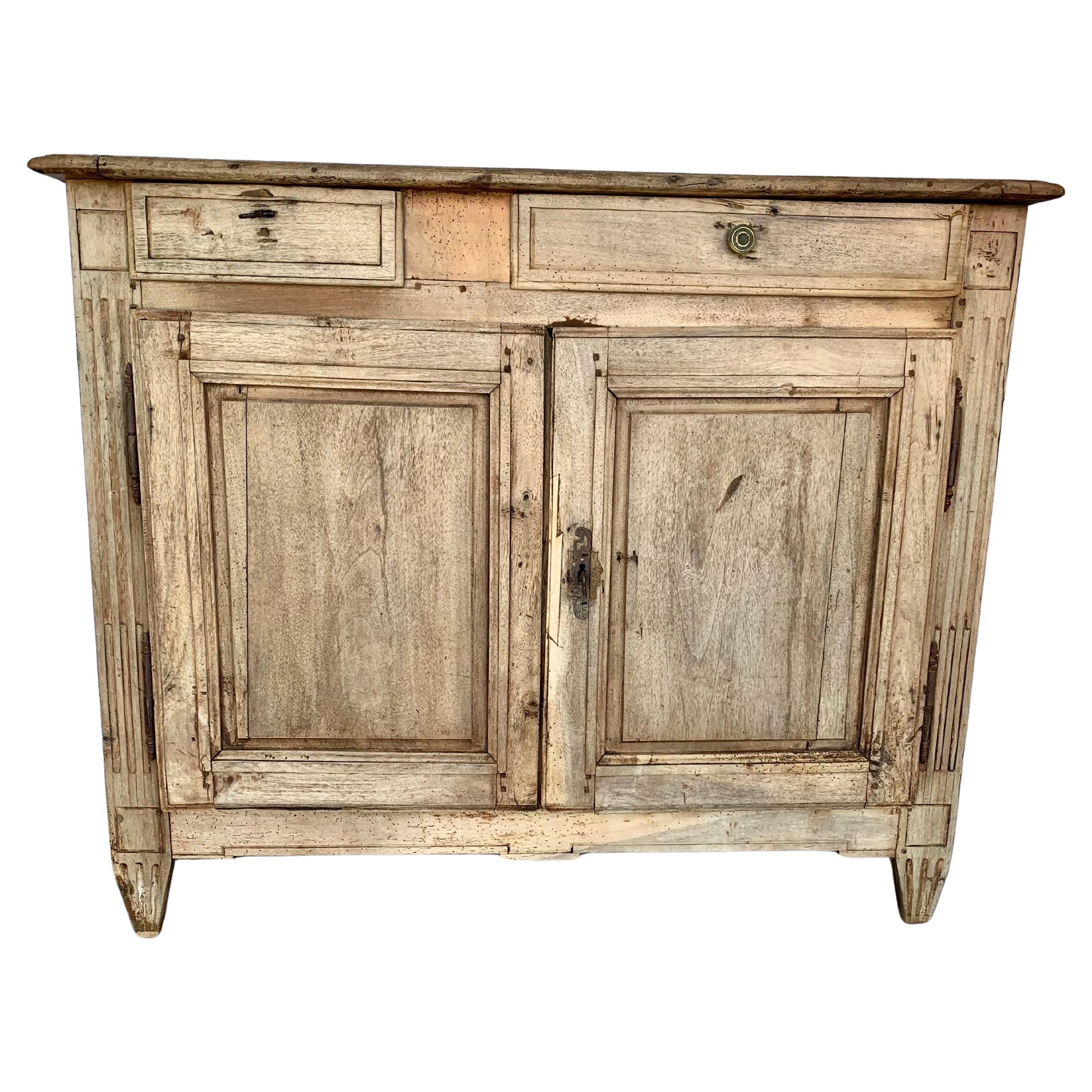 Trouvé dans le sud de la France, ce buffet de la fin du XIXe siècle a été fabriqué en noyer par des artisans français à la fin des années 1800. La pièce a été ramenée à son état de bois naturel et présente un plateau latéral à deux planches de bois