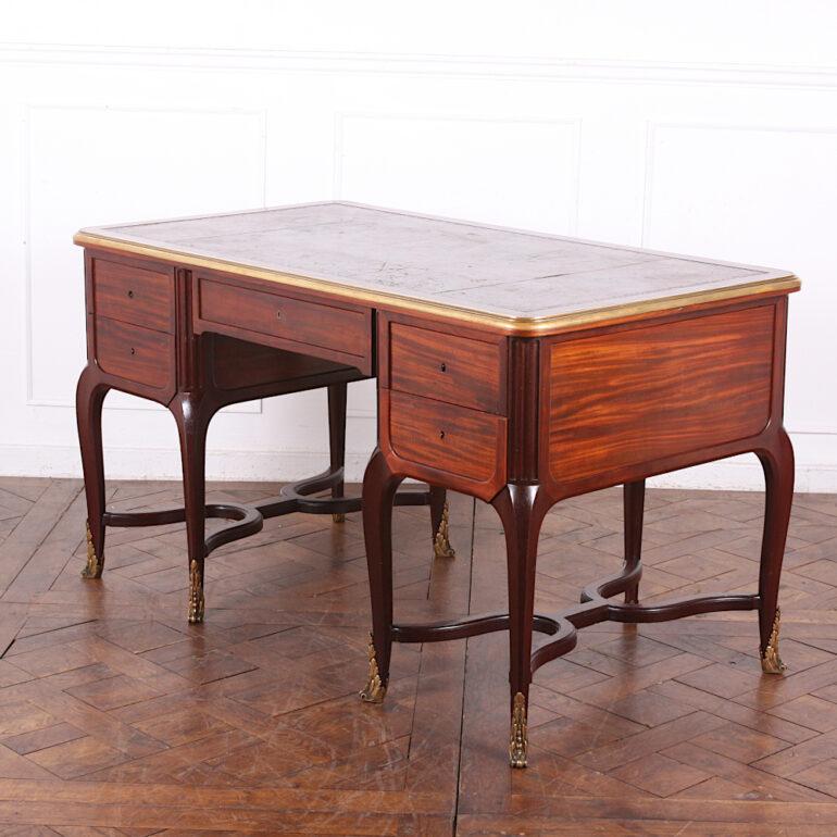A late 19th century French 'bureau plat' or writing desk, each pedestal with two drawers and standing on elegant cabriole legs with ormolu feet, and united by and 'x' stretcher. Finished beautifully all 'round, the top edge with bold solid brass