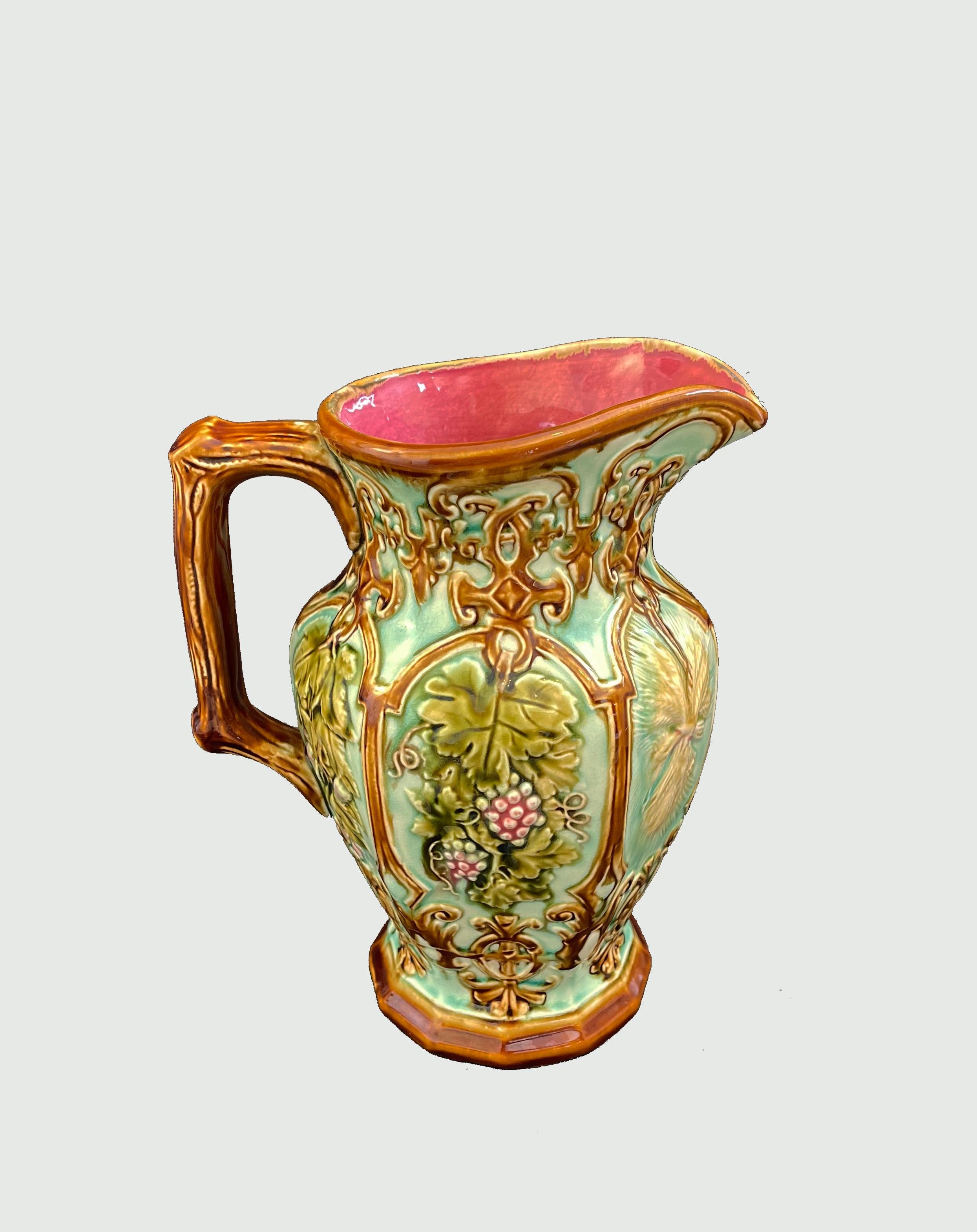 Fabuleux pichet français aux couleurs et fruits d'été magnifiquement combinés par Nimy Les Mons.
Un décor caramel et un fond turquoise clair englobent des raisins roses, des vignes vertes et du blé moissonné.
L'intérieur de la cruche est d'un rouge