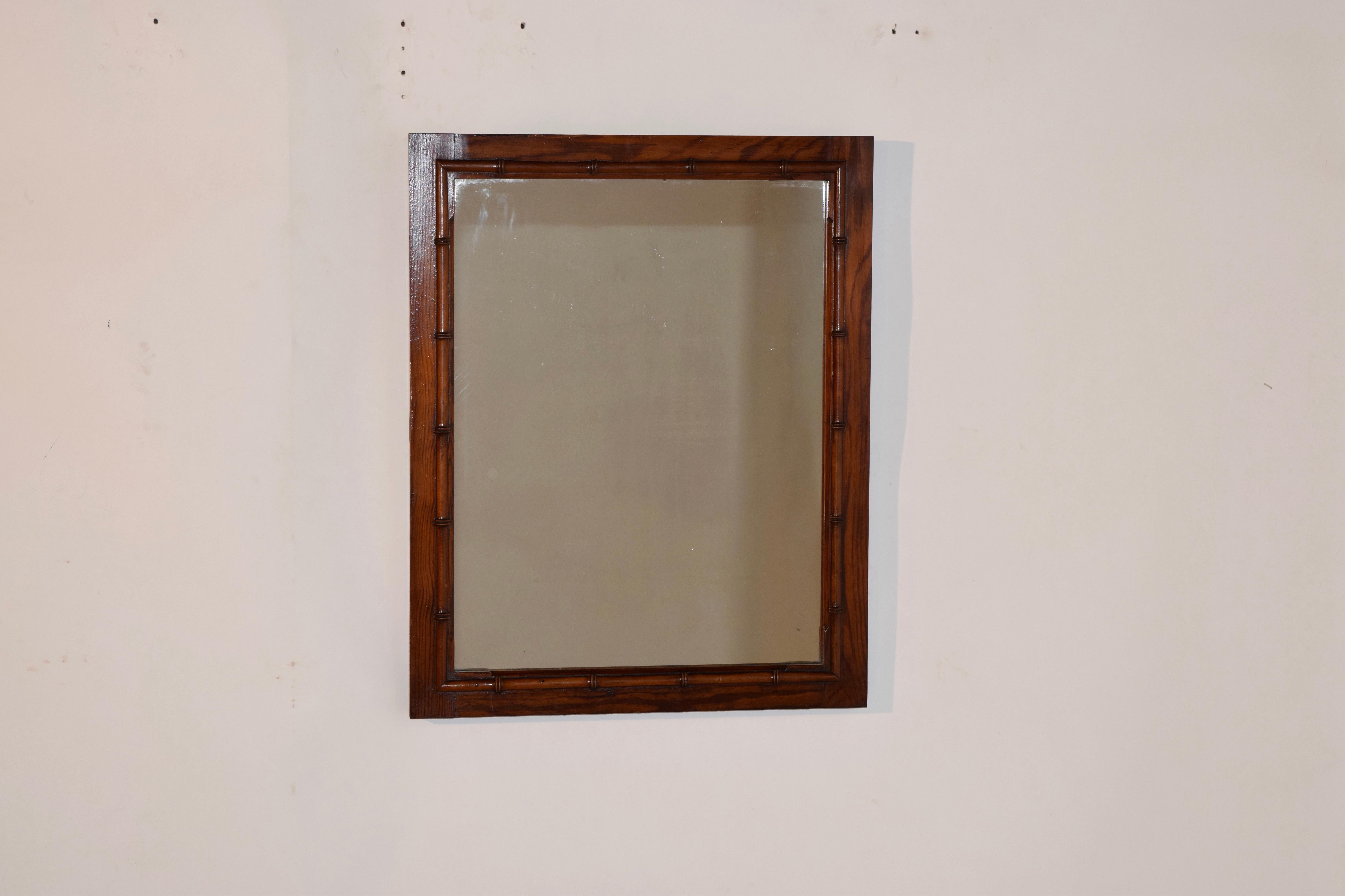 Late 19th century pine and cherry mirror from France with its original mirror. The frame is made from pine and embellished with hand turned faux bamboo molding made from cherry.