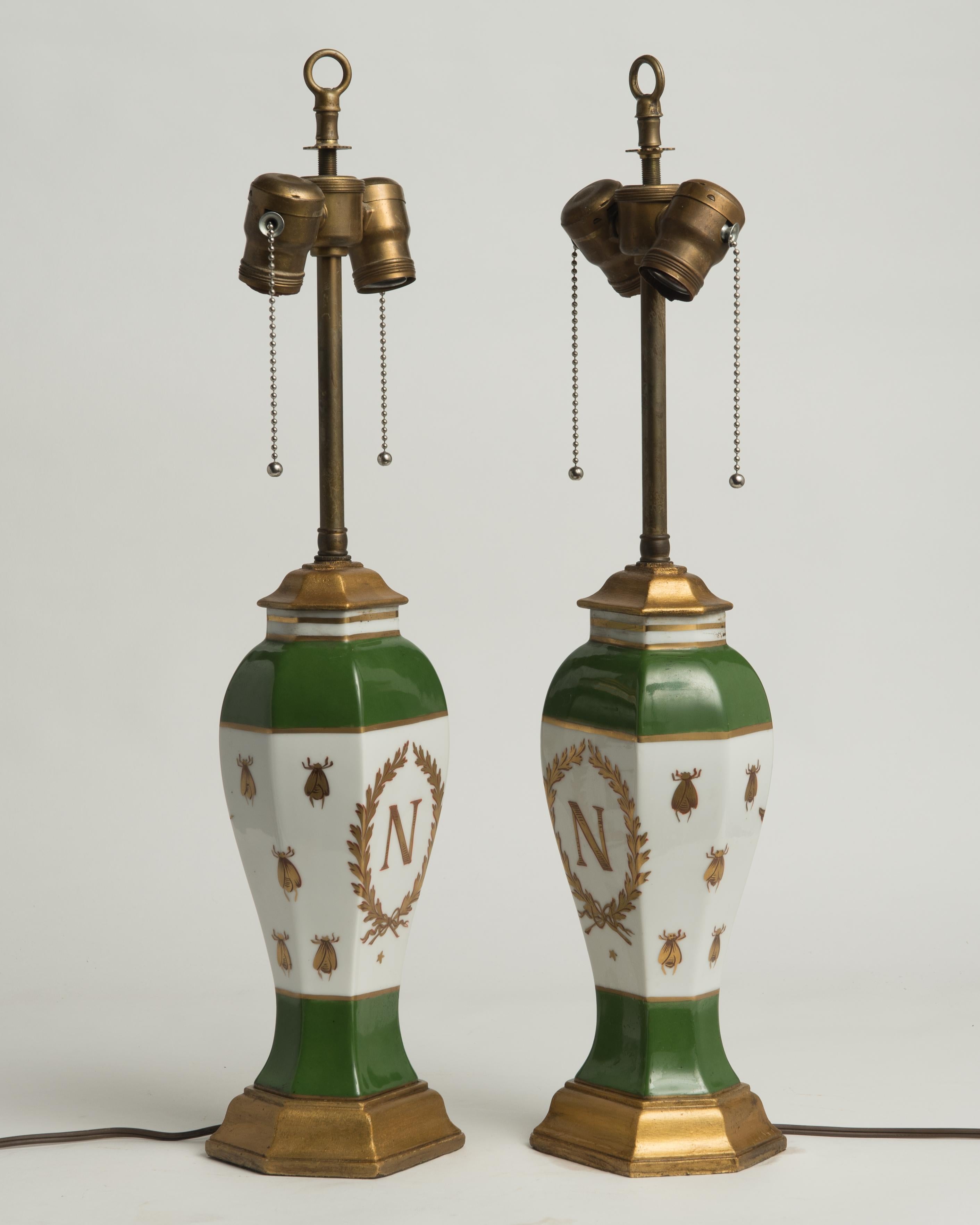 A pair of late 19th century Napoleonic vases in the style of Sèvres, possibly originally made to be lamps or vases made into lamps some time ago. The fronts of the vases depict the 