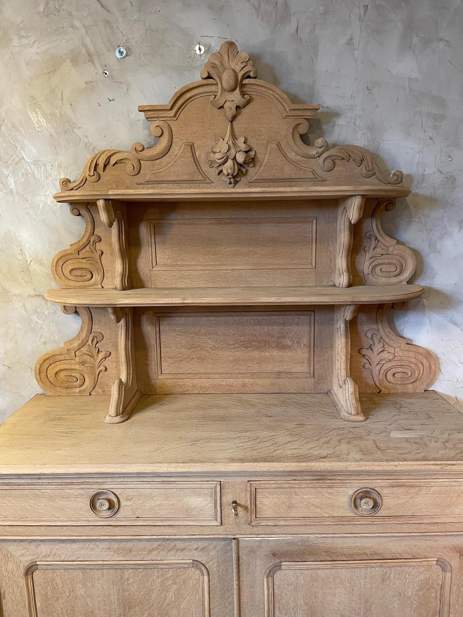 Very nice late 19th century French pickled Oak Saint Hubert buffet from the 1890s. 
Two drawers closed by a key. Two large doors with a long shelf. 
Nice carved wood details. This buffet has been pickled thanks to a sand process that makes the