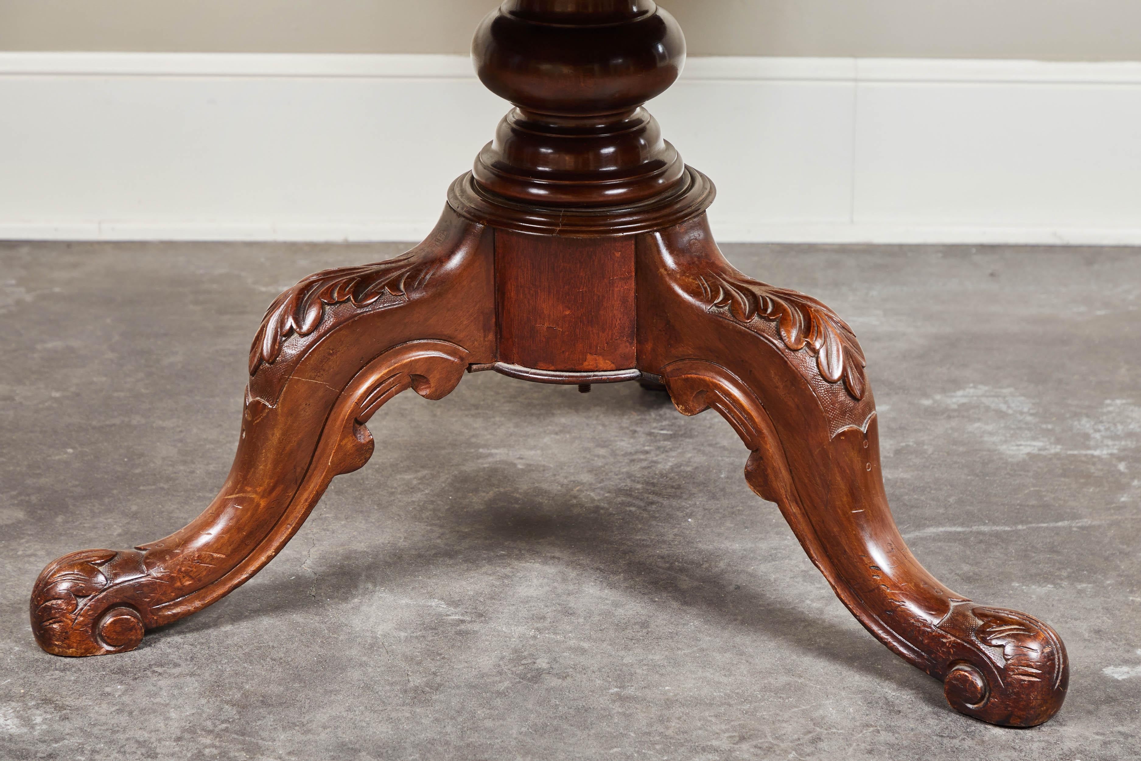 A handsome late 19th century French pedestal table with intricate carvings of acanthus leaves in the legs and feet.