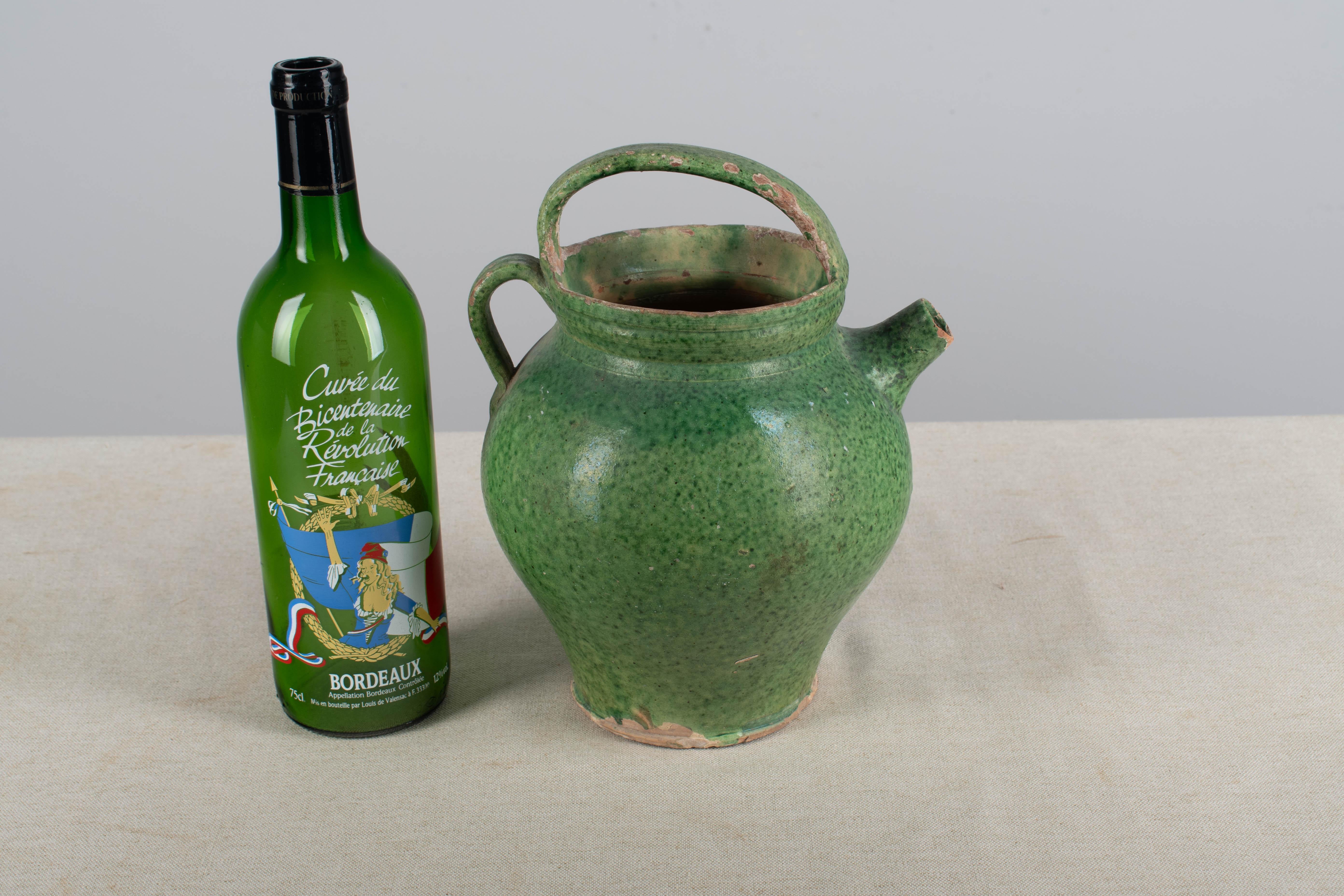 A late 19th  terracotta vinaigrier, or vinegar pot, from the Southwest of France. Traditional form with beautiful green glaze. In  good original condition with the usual wear for its age and use. Chips on the rim and body. Please refer to pictures.