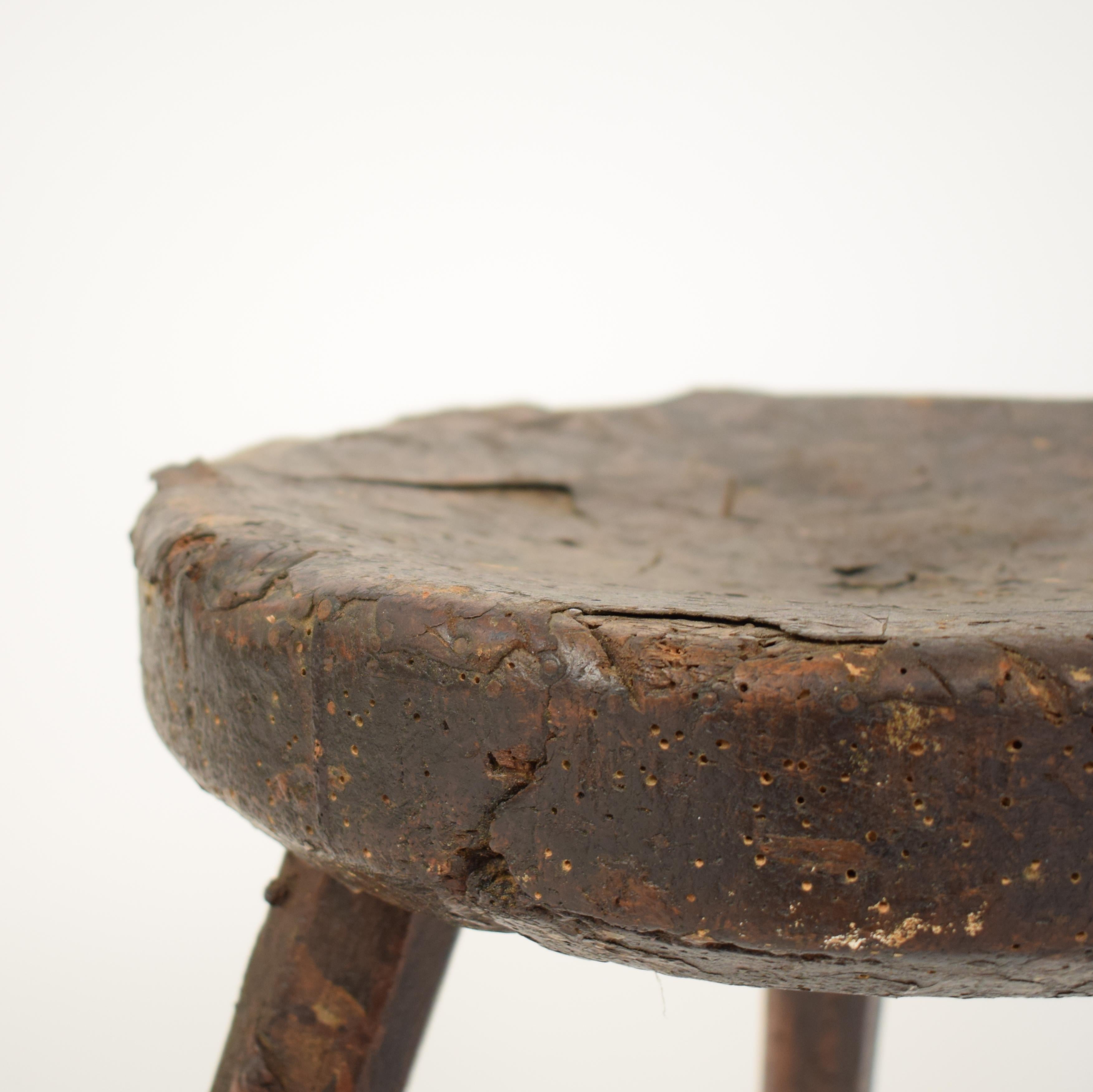 This primitive French elm country splayed leg wood stool was made in the late 19th century, circa 1880.
It has a leather cover over the seating part.
It has this perfect Wabi Sabi look and is just beautiful in style and Patina.

A unique piece
