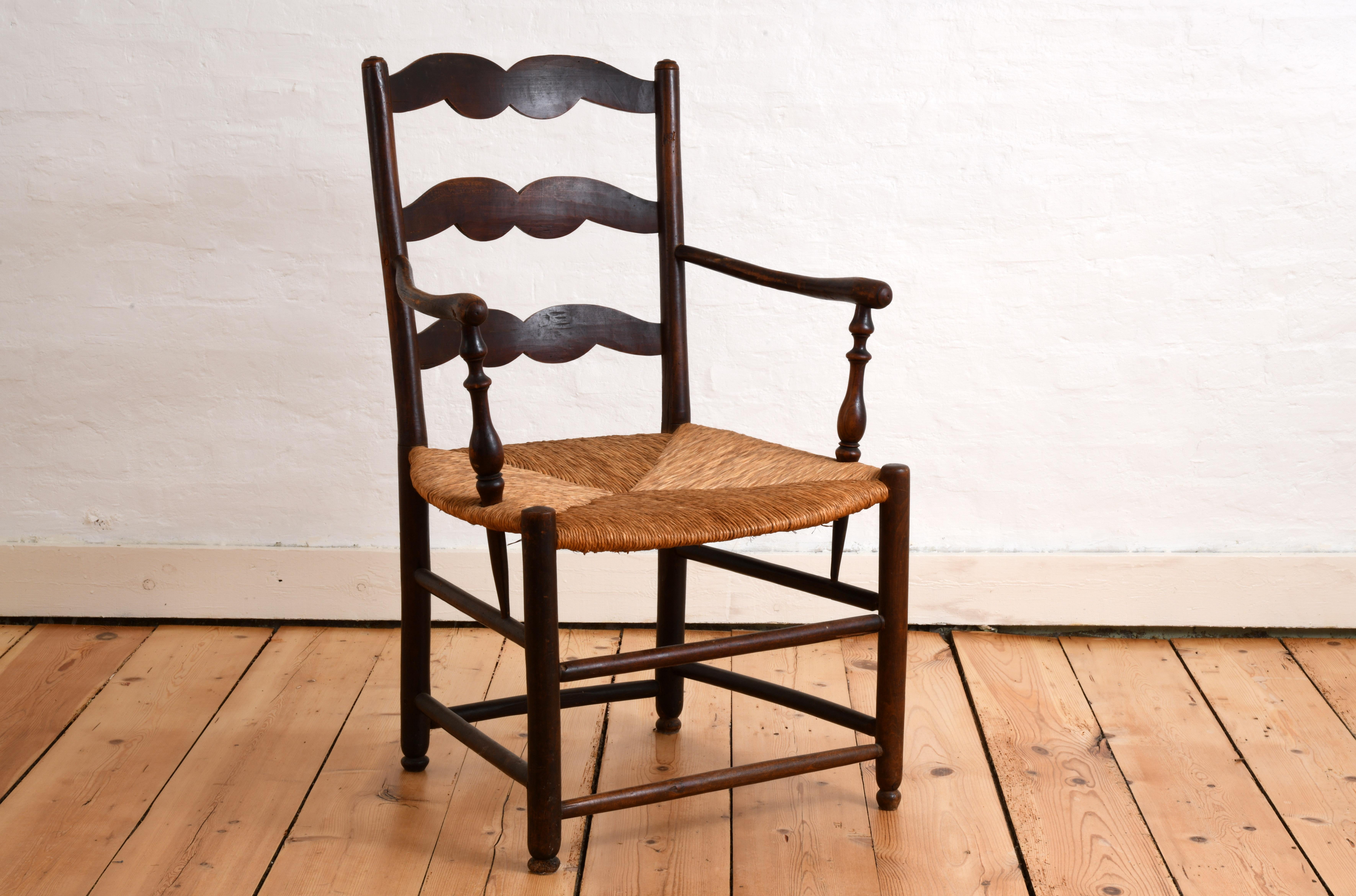 Sillón de finales del siglo XIX/principios del XX en madera teñida con asiento de paja, típico de la región francesa de Provenza. Respaldo con tres listones en forma de 