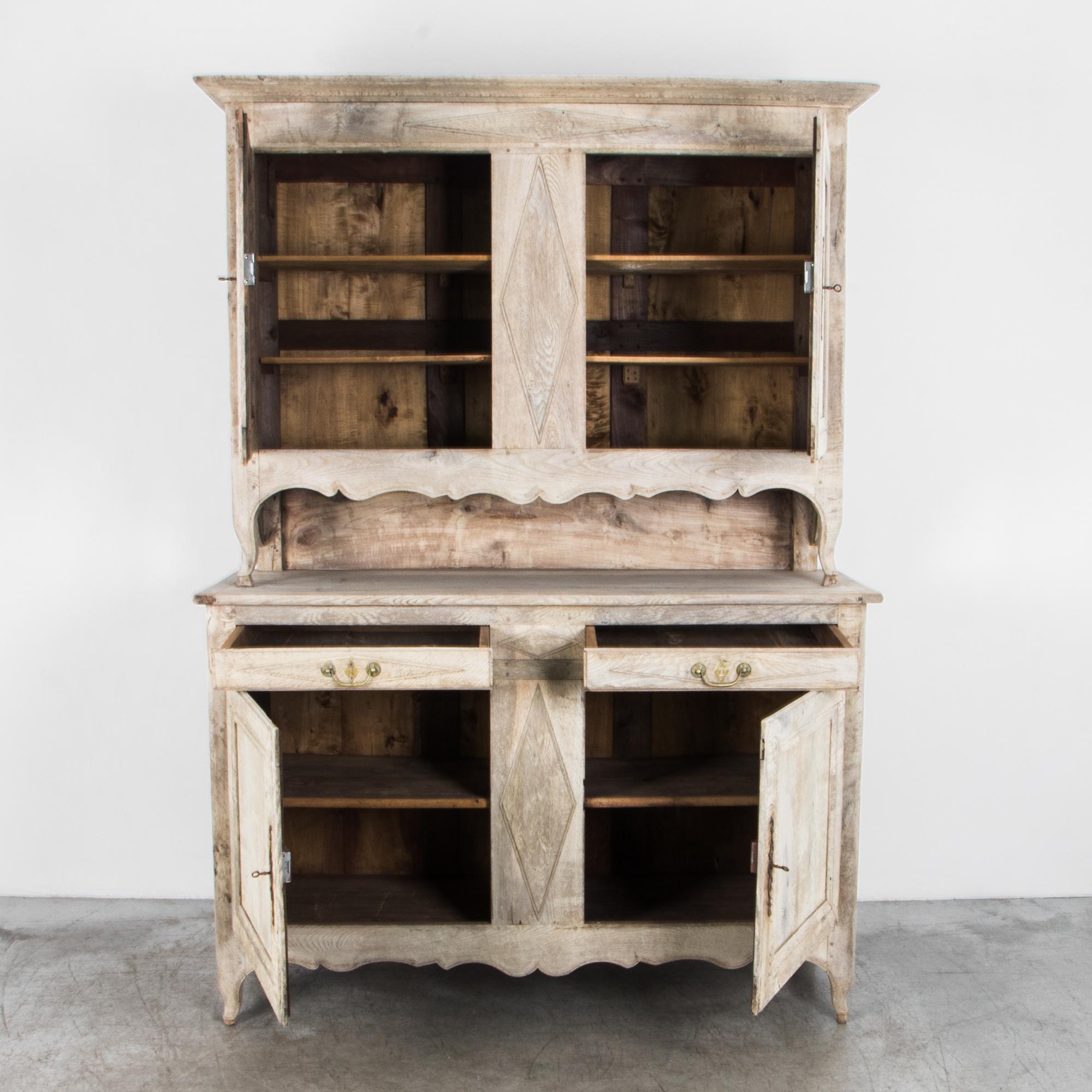 This antique oak cabinet hails from 1880s, France. Fully refinished and restored, the bleached oak exterior opens to reveal a striking dark finish. A buffet “a deux corps,” or “in two bodies,” combines an upper and a lower cabinet, each with two