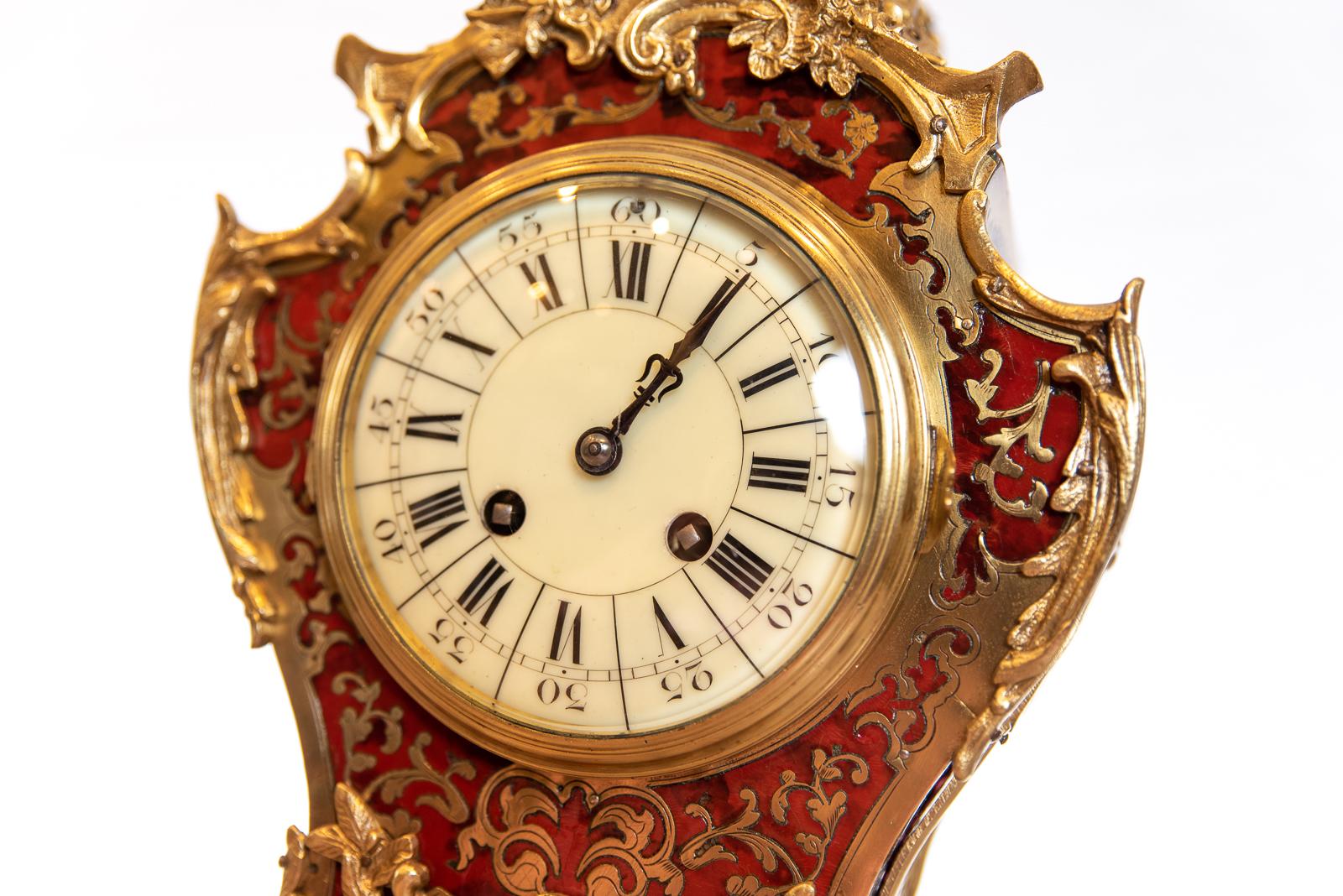 A late 19th century, French red tortoiseshell Boulle work mantel clock with circular off-white dial with Roman numerals. Enclosed by a brass bezelled door with gilt acanthus case. The back plate of the movement signed Marti (makers in Paris,