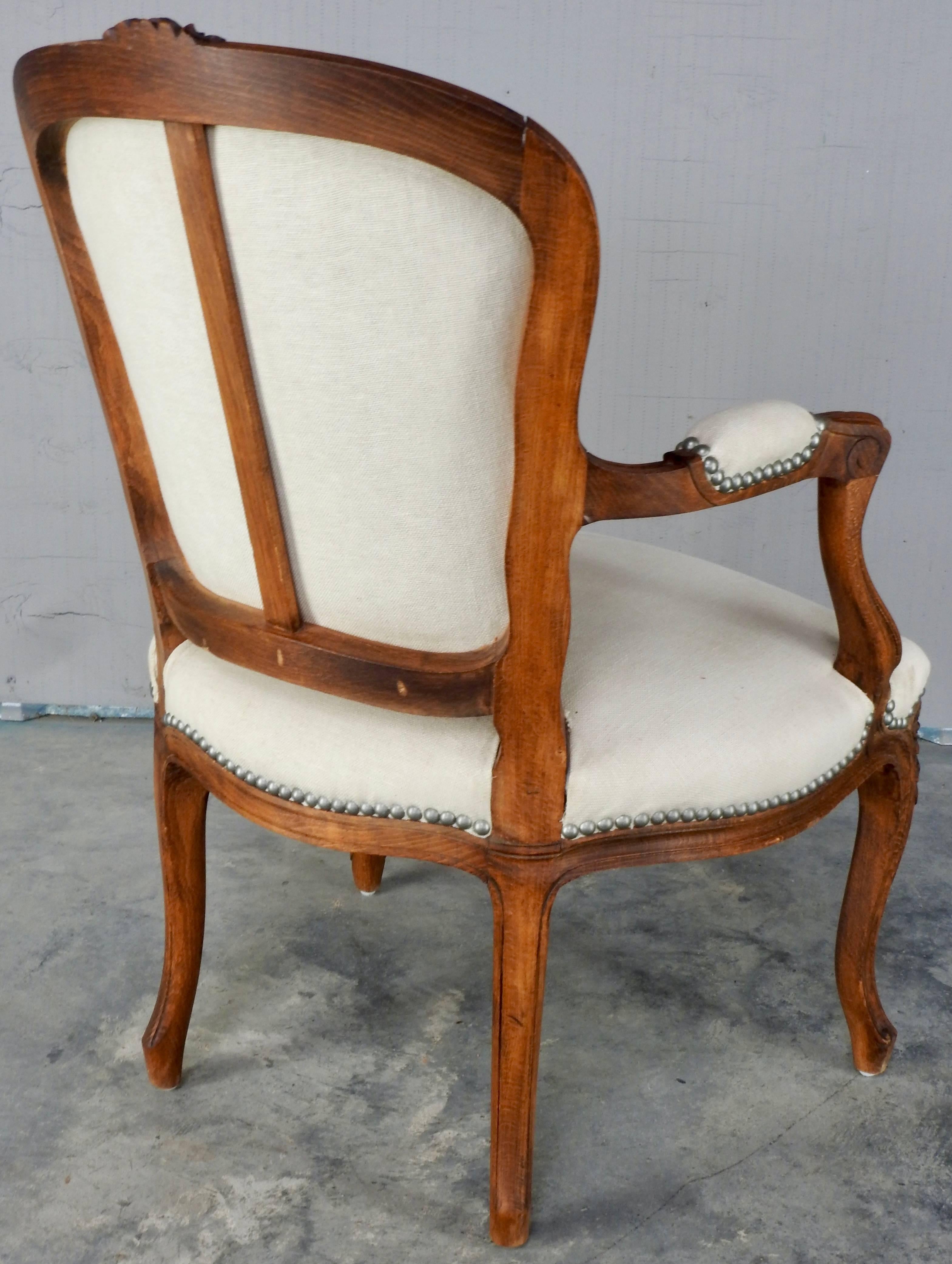This chair is a beautiful warm walnut in the traditional Rococo style. Covered in a gorgeous Belgian linen this chair will add warmth and texture to any room. Pewter tacks make the linen pop out.