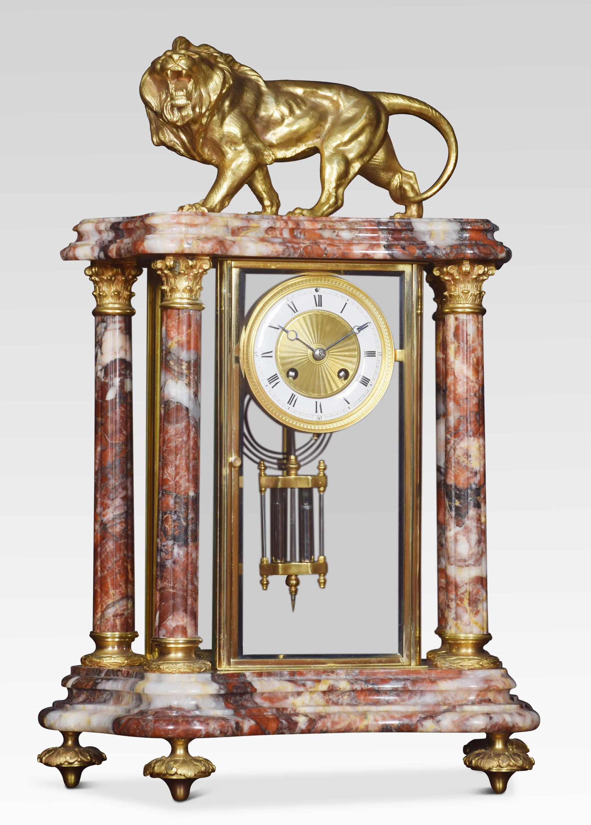 Late 19th century French clock set, the architectural marble case surmounted with a gilt metal lion, above four gilt embellished Corinthian columns. The case fitted with four glass panels enclosing the enameled dial with a gilt metal centre,