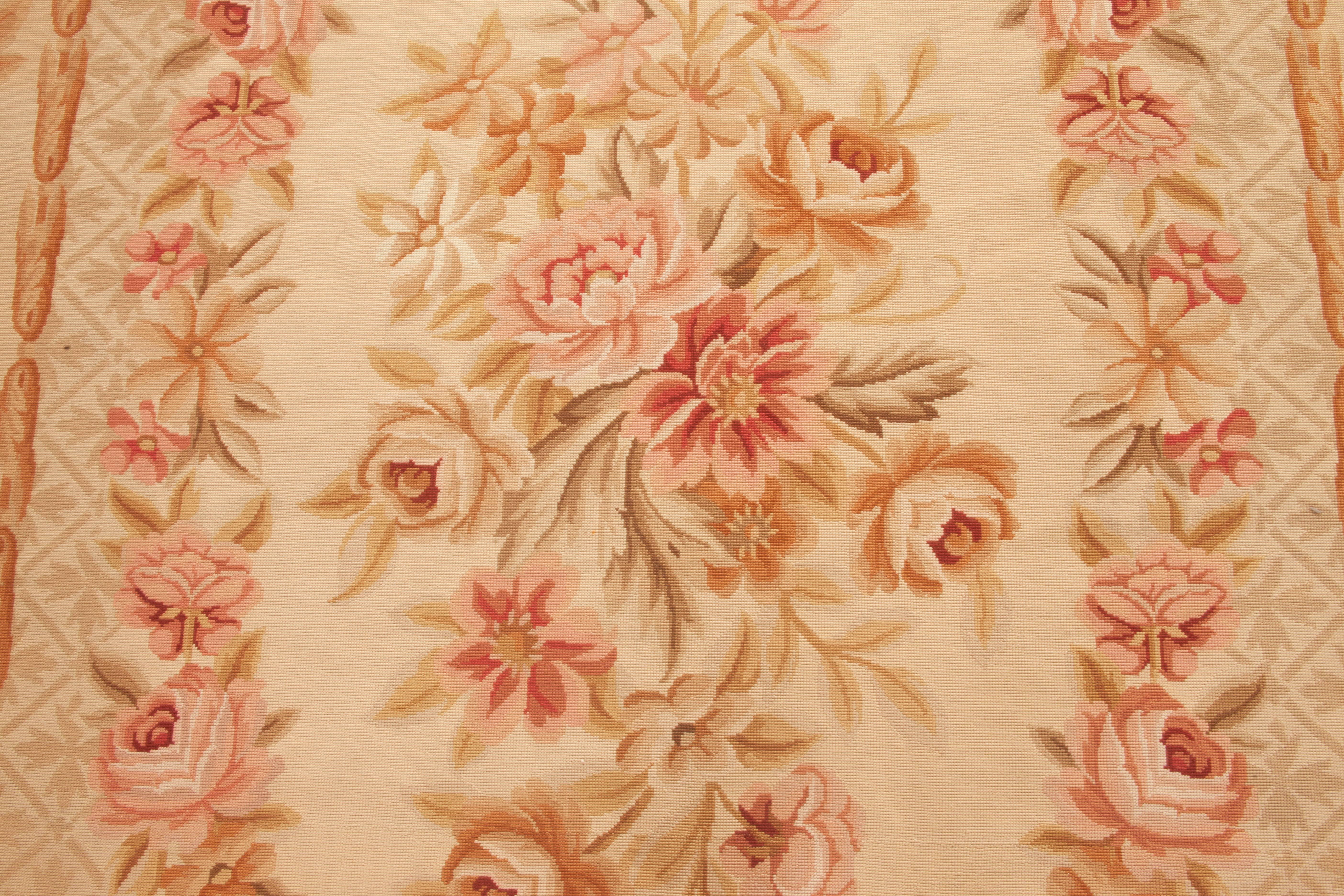 An exquisite example of a revival of an 18th century design, the rug exhibits a floral oval medallion with four corner bouquets on a golden cream field with a latticework of acanthus surrounded by tendrils of ivy and flowers. Olive, gold, rust,