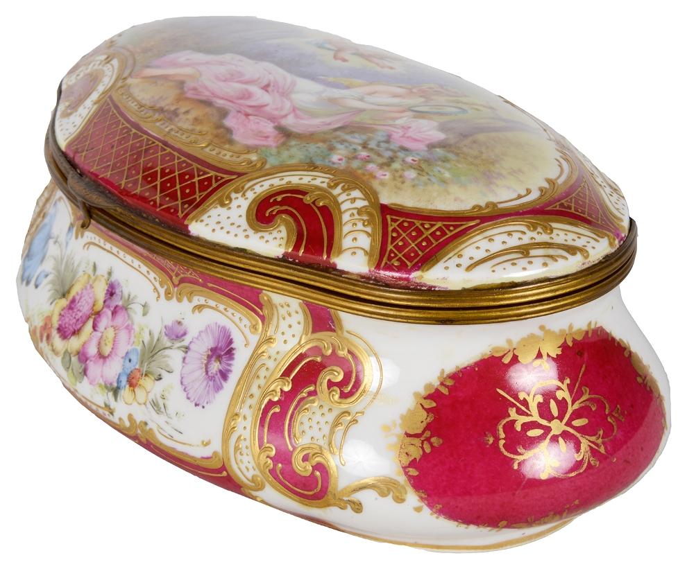A very decorative late 19th century French Sevres style porcelain, hand painted casket. Having a Burgundy colour ground, with an inset painted panel of flowers, and a classical scene to the lid of a reclining maiden with a cherub above her.