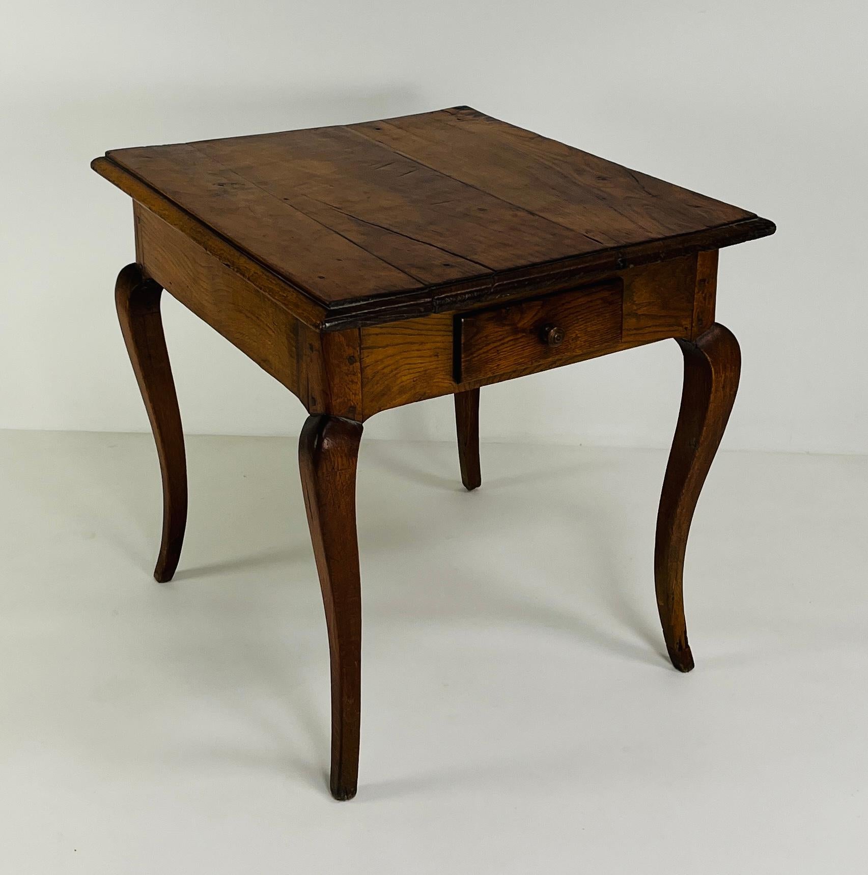 A graceful and compact French side table dating to the late 19th century, this piece embodies the quiet refinement of provincial craftsmanship. Made circa 1880, it features a rectangular top with beautifully aged wood grain and subtle surface